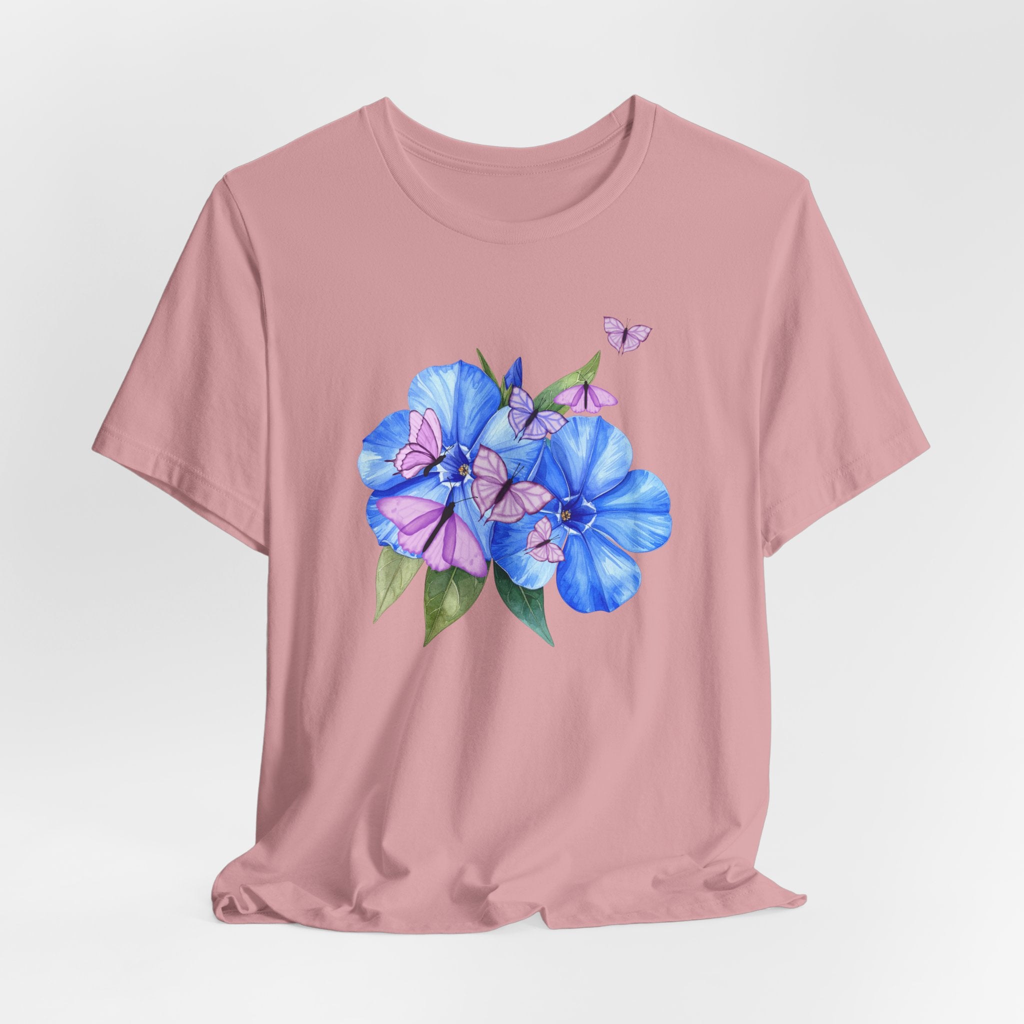 Pink t-shirt with blue floral design on a light gray background
