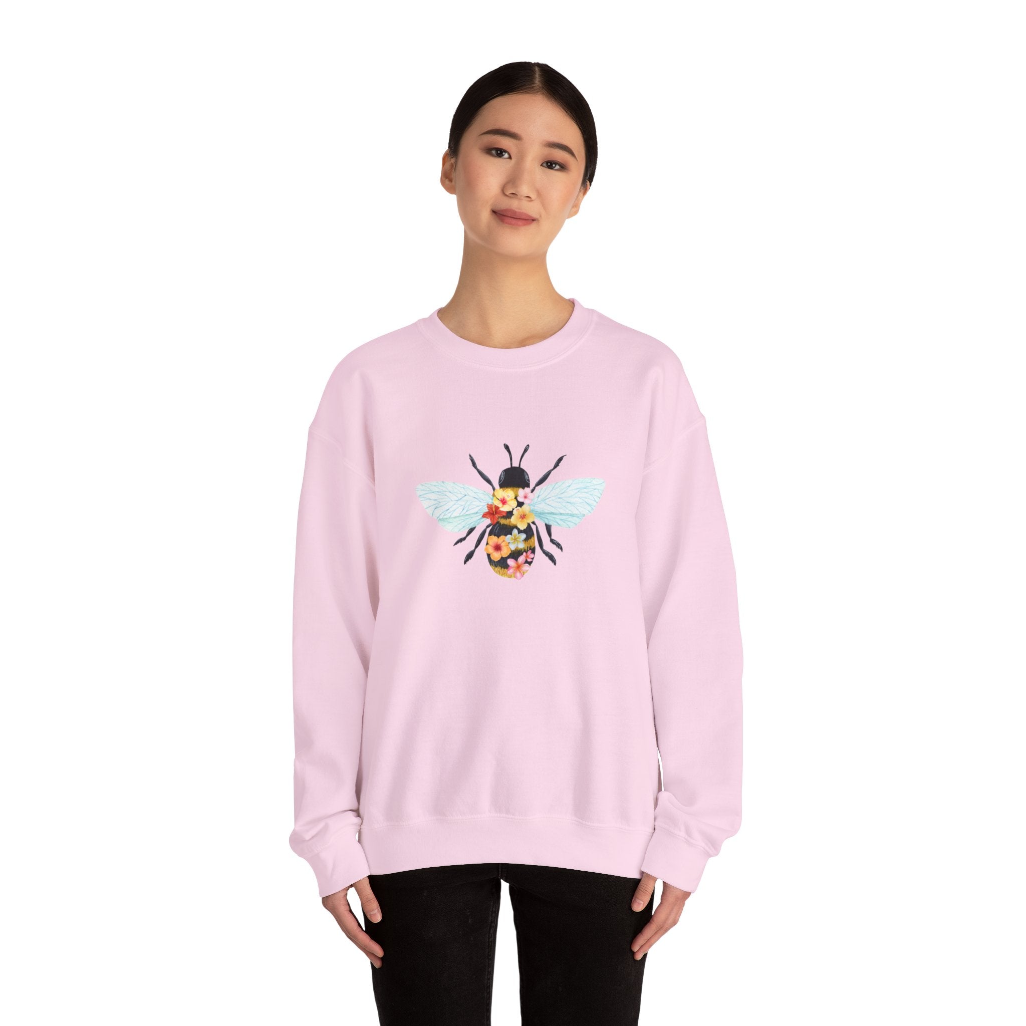Person wearing a white sweatshirt with bee and flower pattern on a white background
