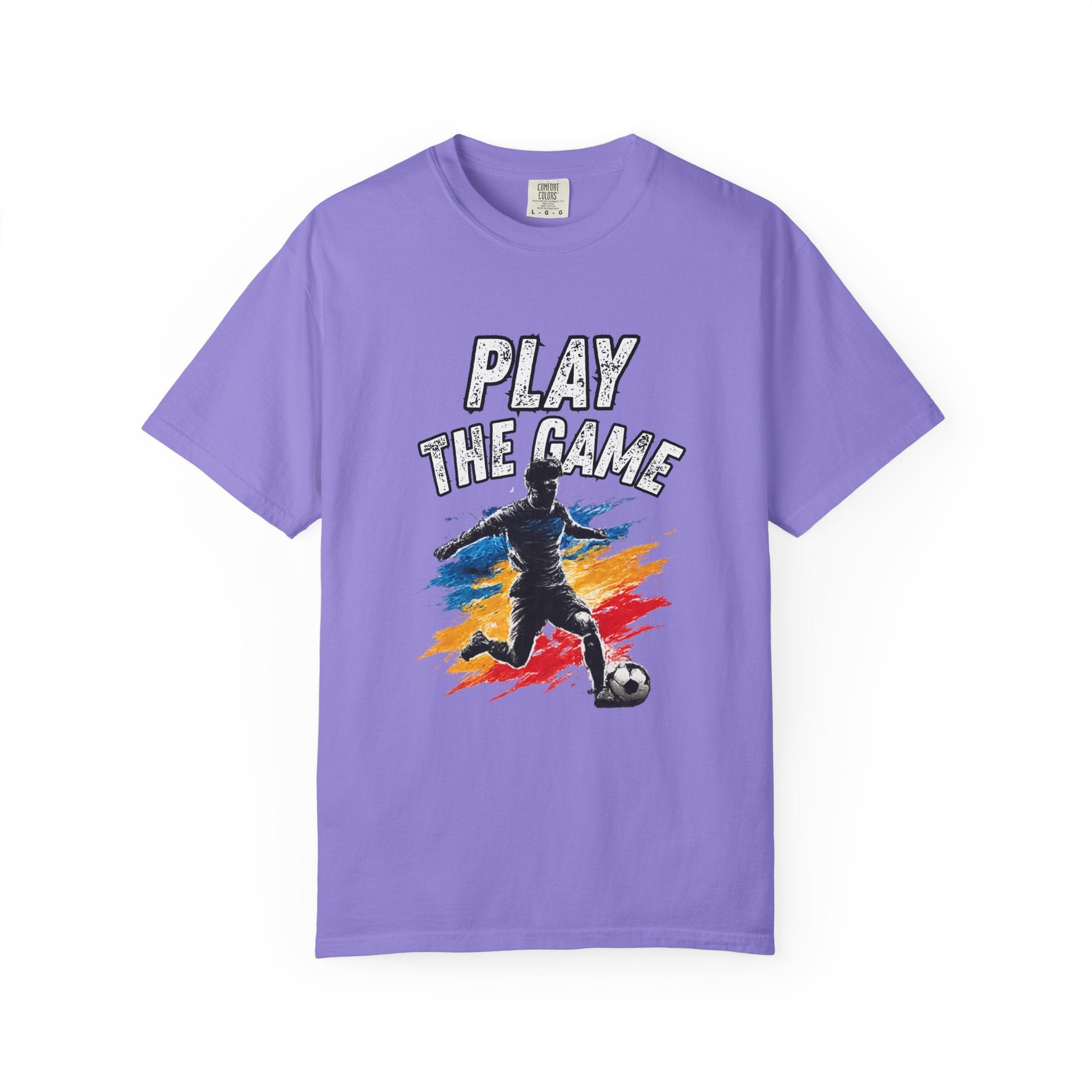 A purple short-sleeve crewneck t-shirt featuring a graphic print of a soccer player kicking a ball with the text 'PLAY THE GAME' in white, set against a clean white background.