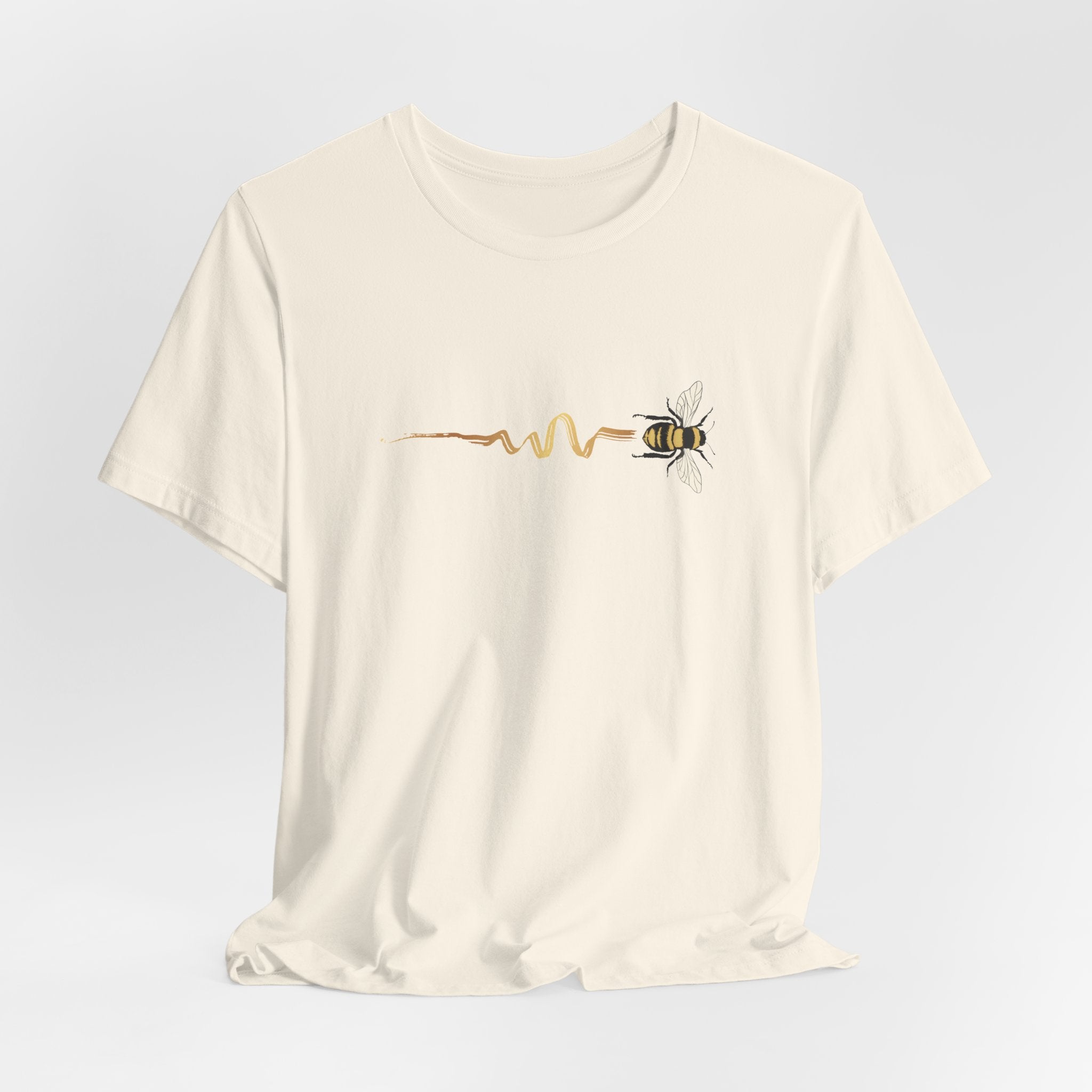 Beige t-shirt with a bee and heartbeat line design on a light gray background