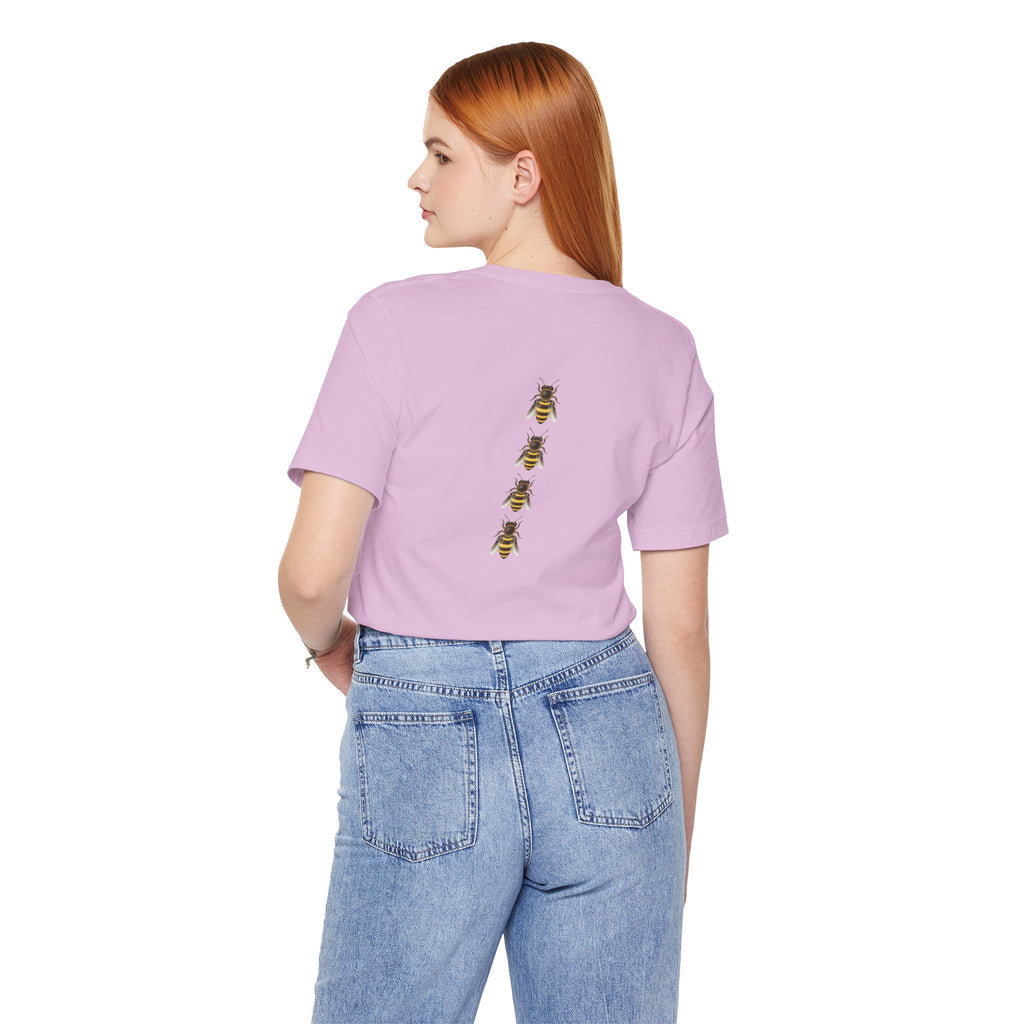 Person wearing a light purple t-shirt with bee designs on the back, standing against a white background.