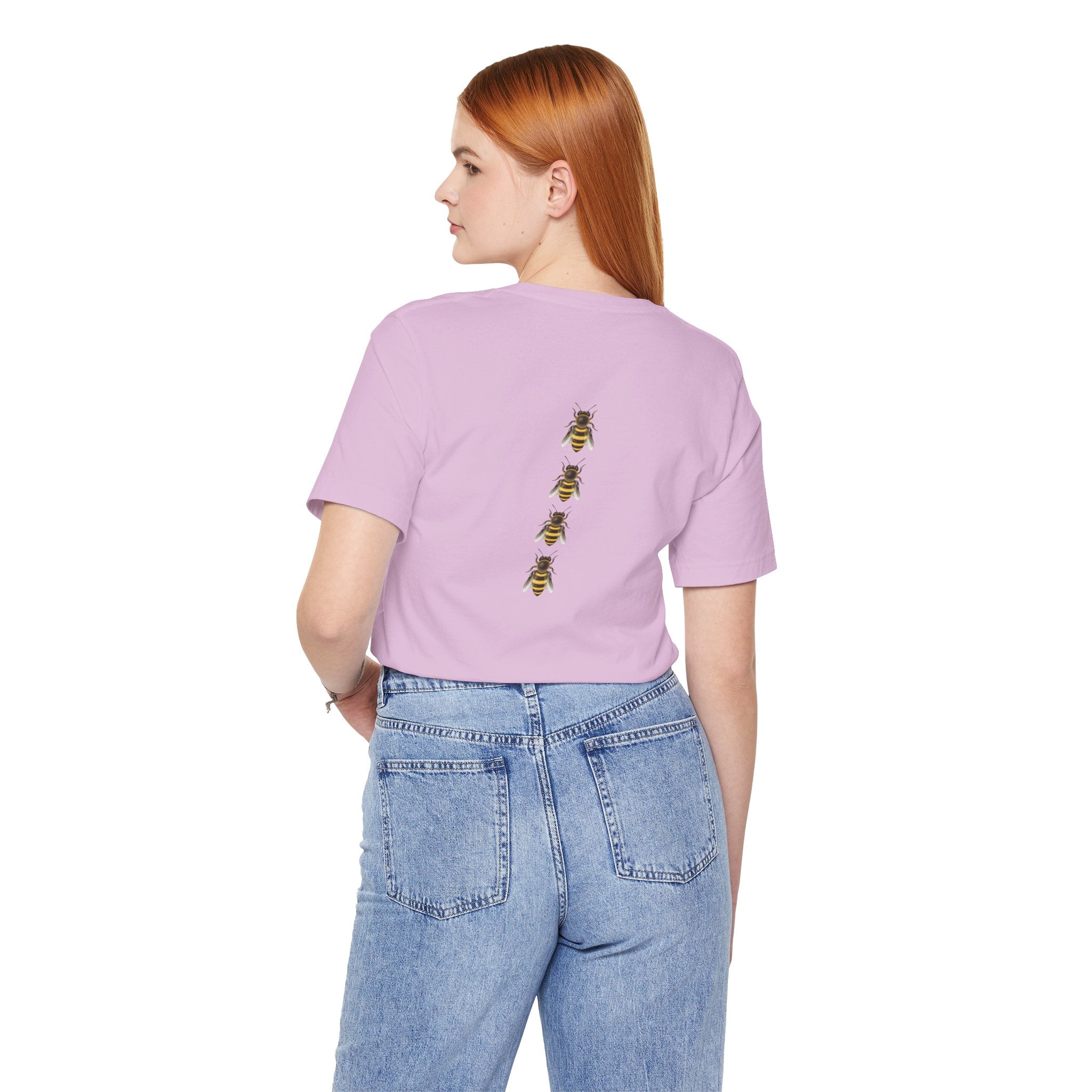 Person wearing a light purple t-shirt with bee designs on the back, standing against a white background.