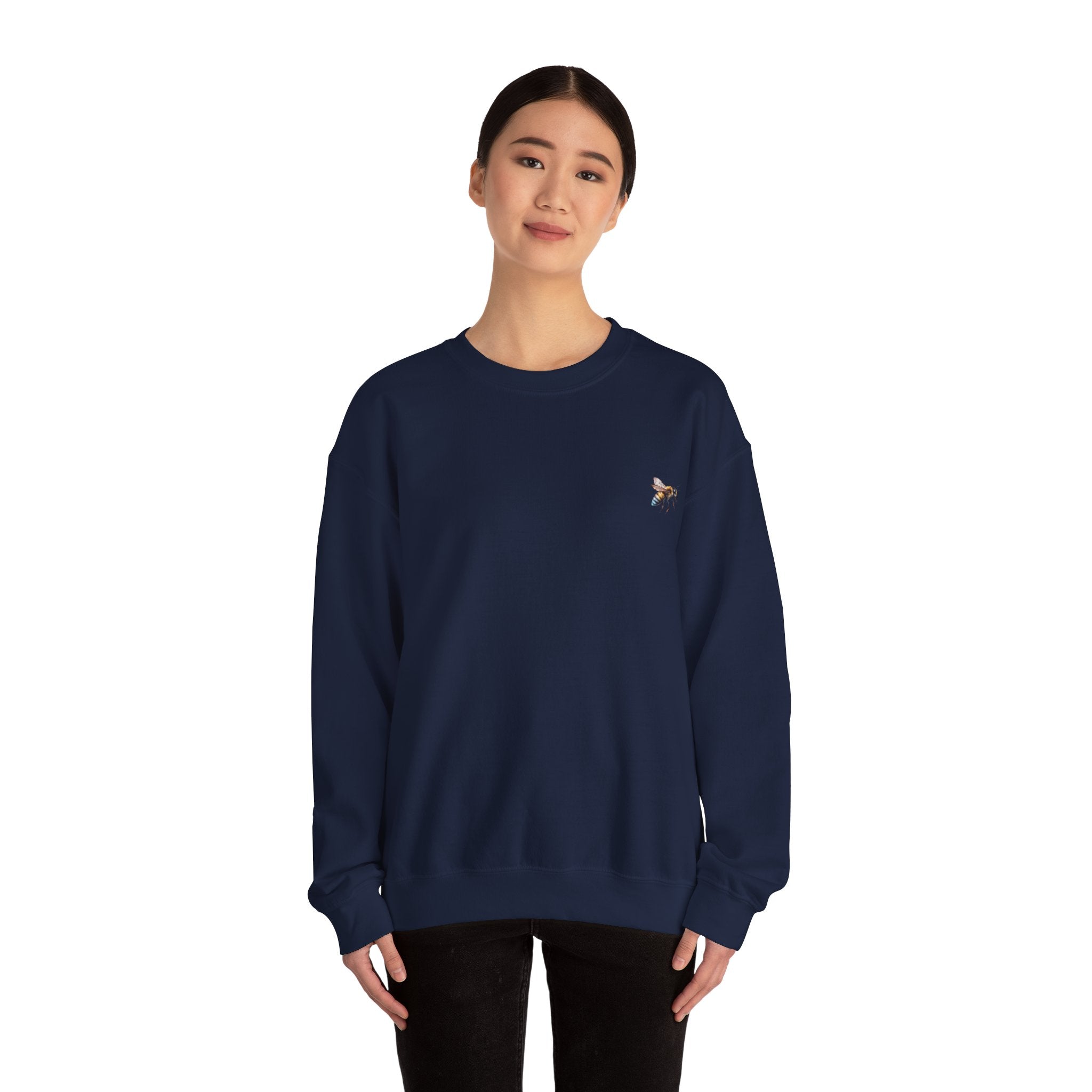 Person wearing a navy blue sweatshirt with a small bee logo on a white background