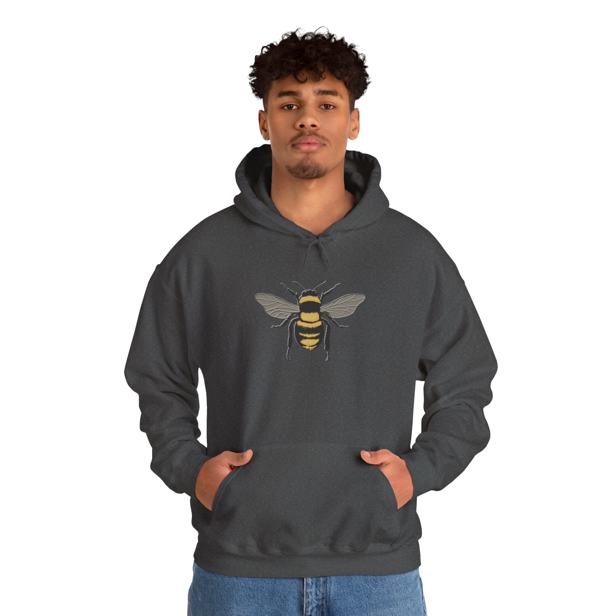 Person wearing a dark gray hoodie with a bee design on a white background
