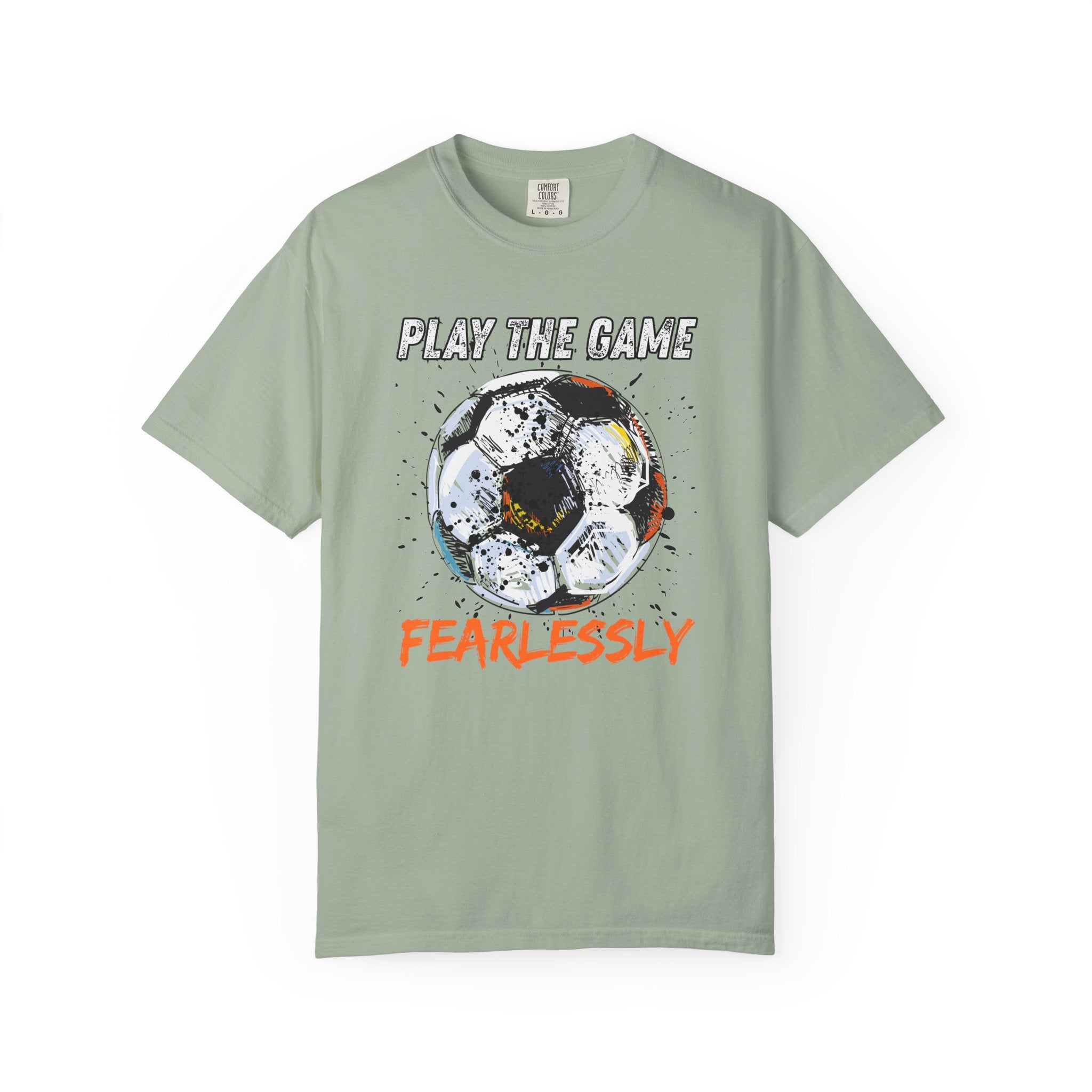 Light green t-shirt with dirty soccer ball graphic and play the game fearlessly text on a white background