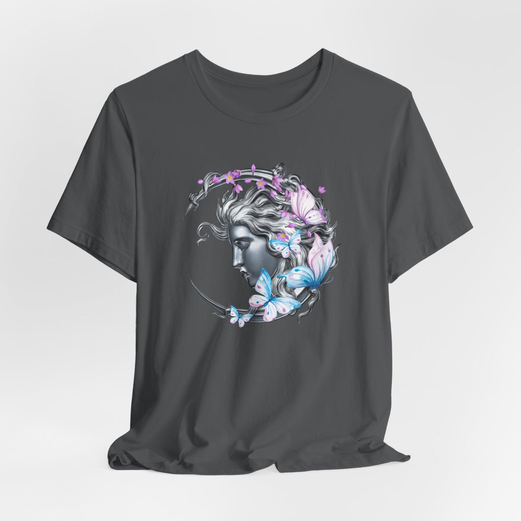 Gray t-shirt with a decorative design of a face surrounded by flowers and butterflies on a light gray background.