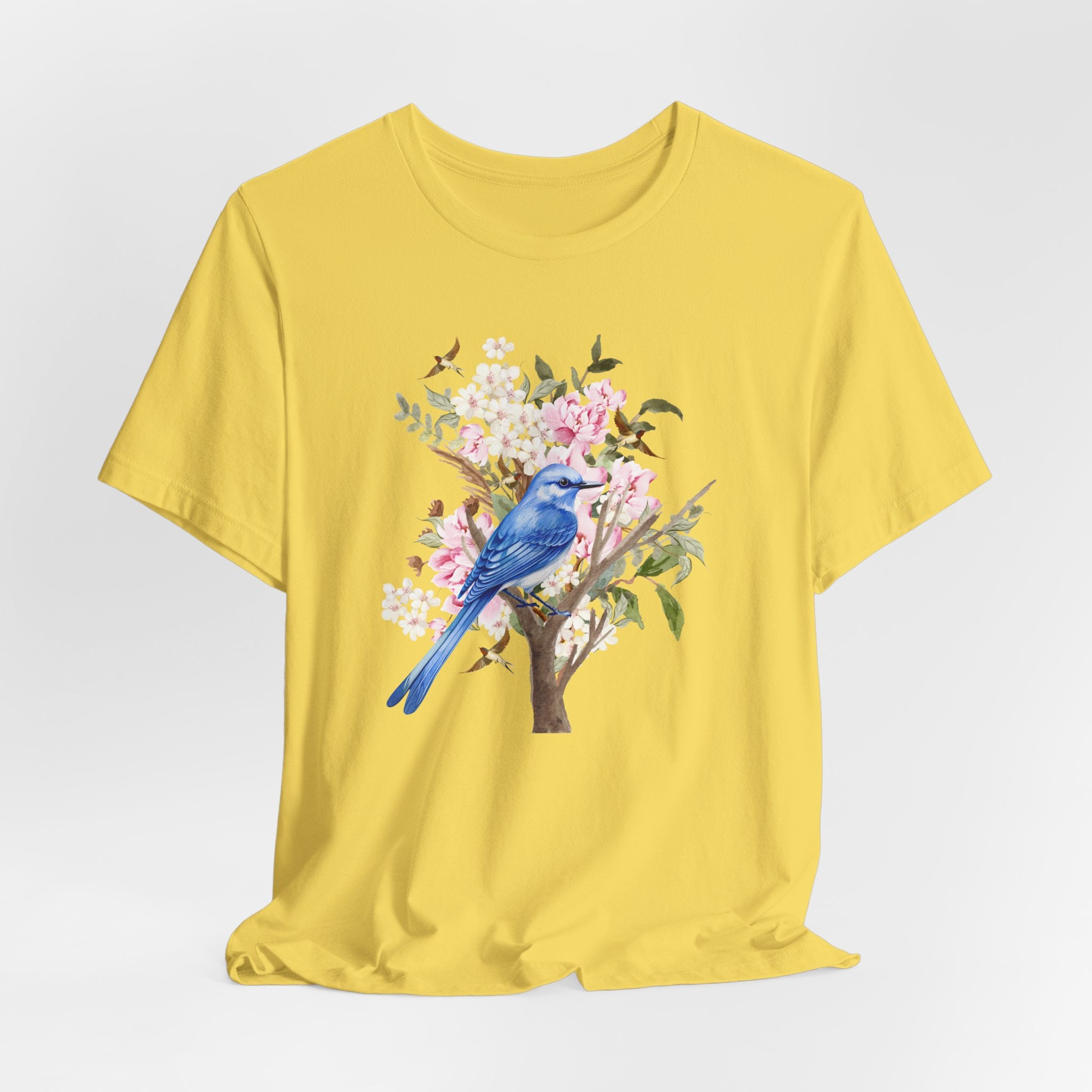Yellow t-shirt with a blue bird and floral design on a white background