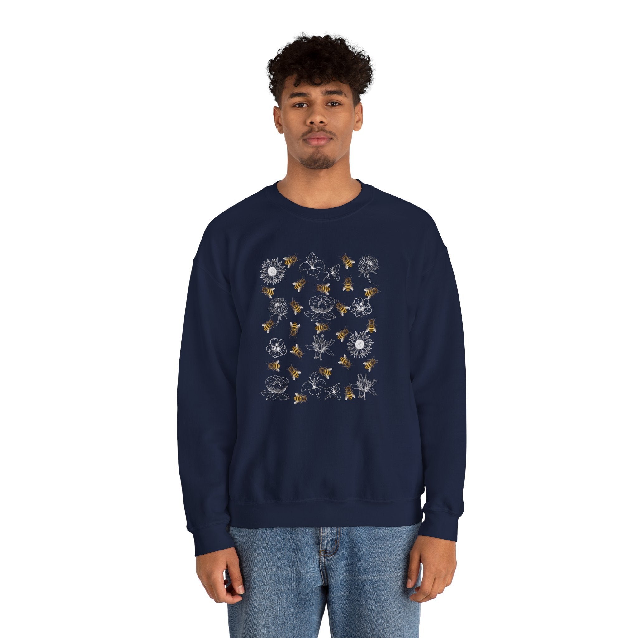 Person wearing a navy blue sweatshirt with bee and flower pattern on a white background