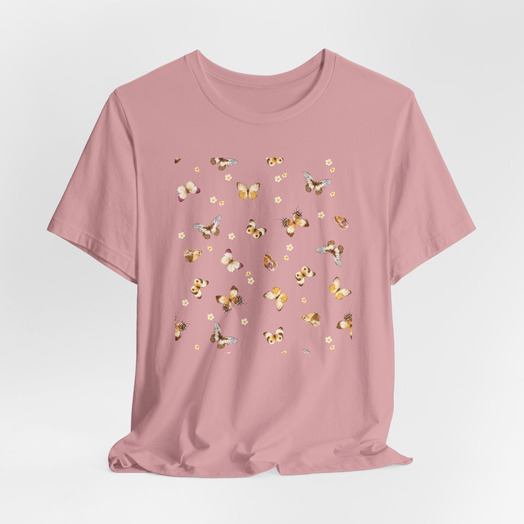 Pink t-shirt with gold butterfly designs on a light gray background