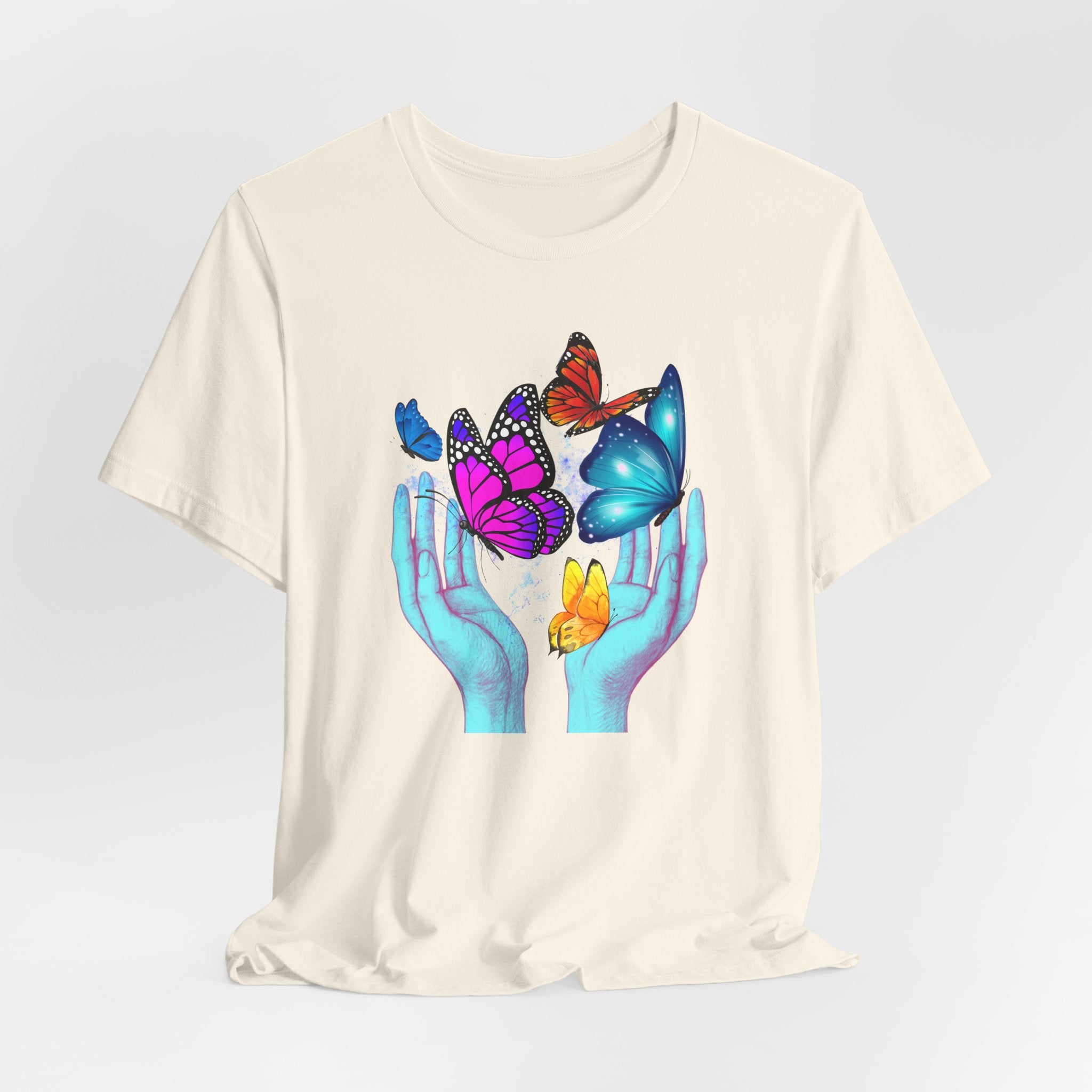 White t-shirt with colorful butterfly design on a plain background