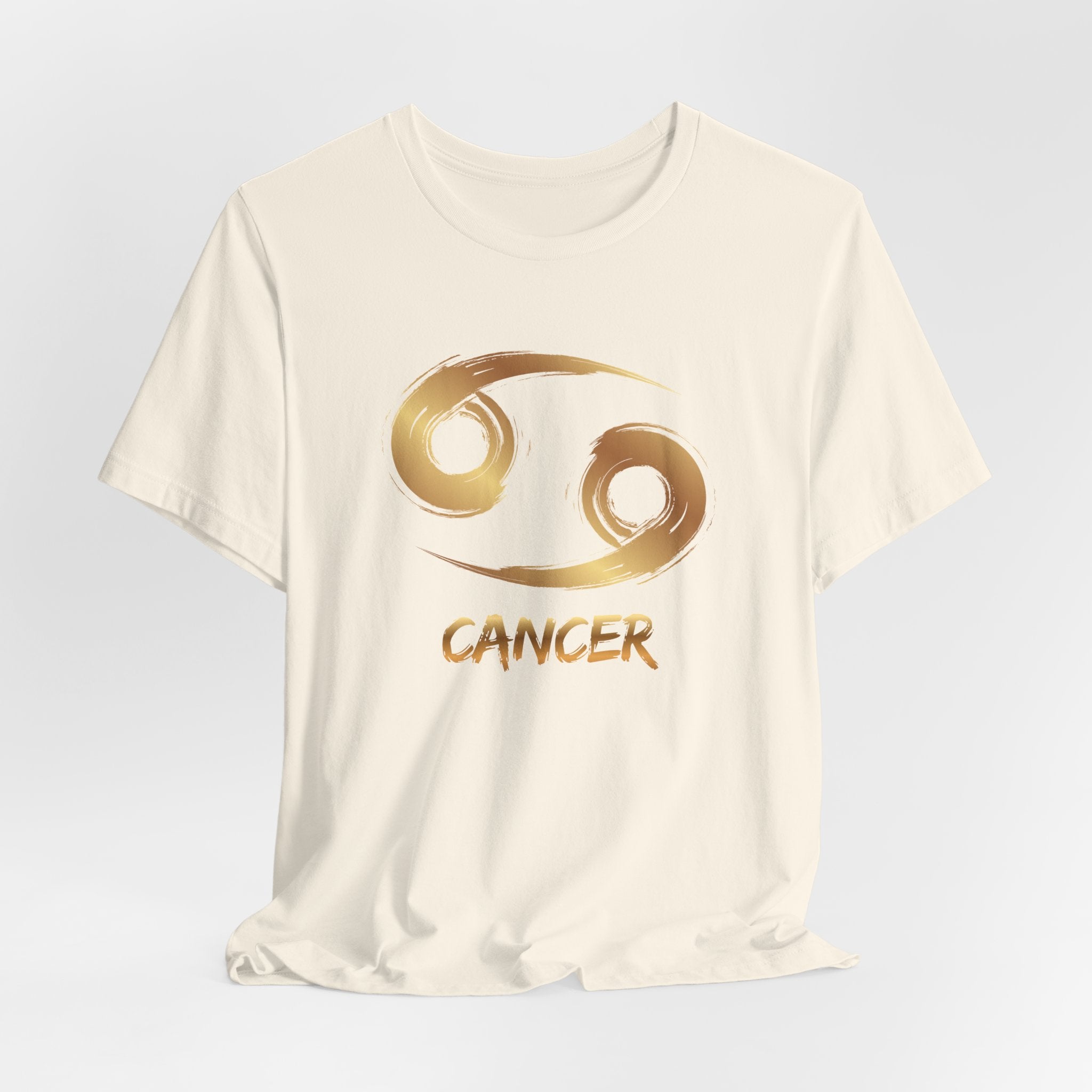 White t-shirt with gold Cancer zodiac symbol on a light gray background