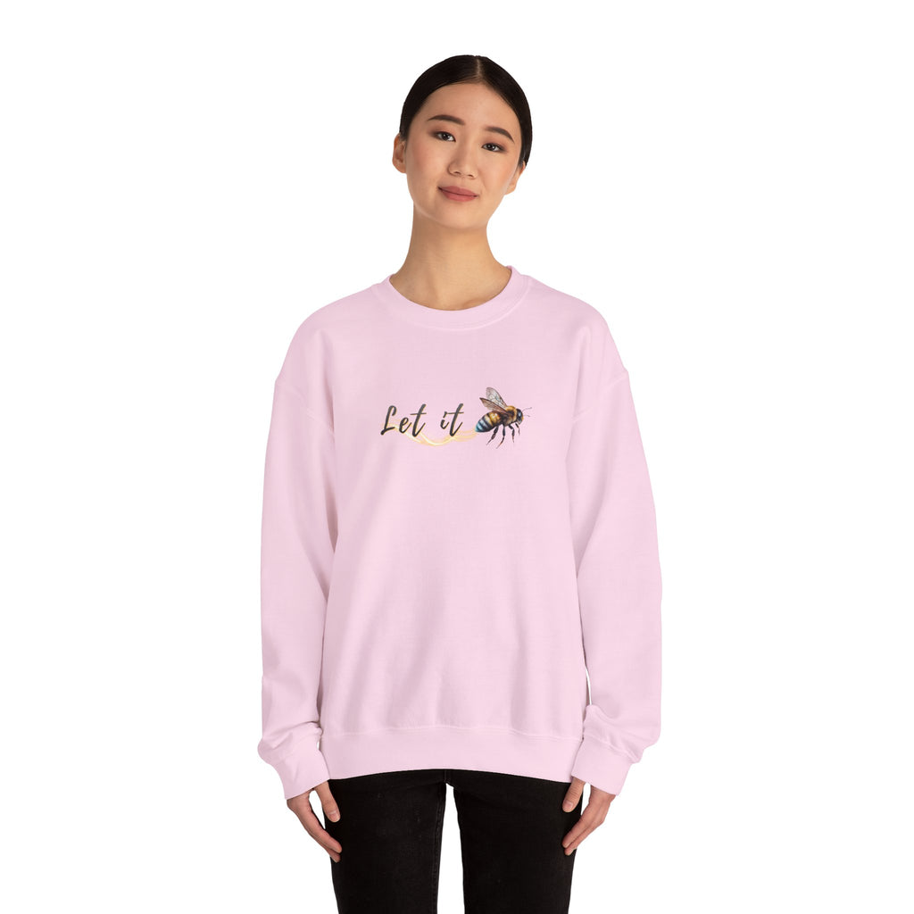 Person wearing a pink sweatshirt with a bee and 'Let It' text design on a white background