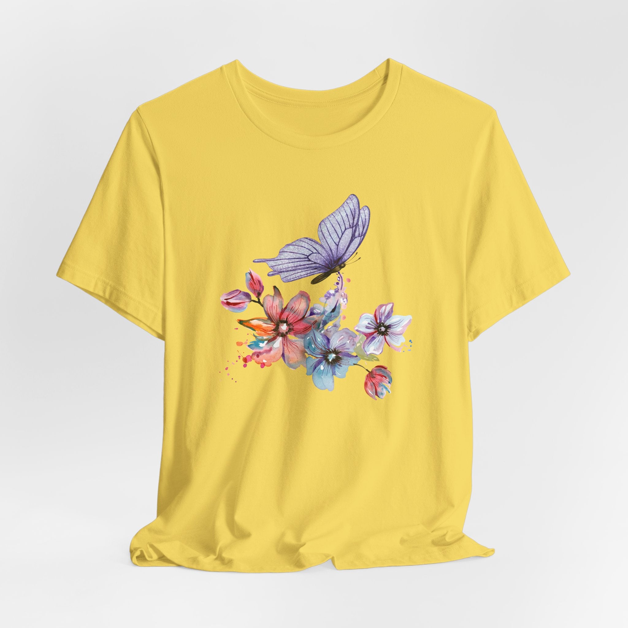 Yellow t-shirt with a colorful butterfly and floral design on a white background