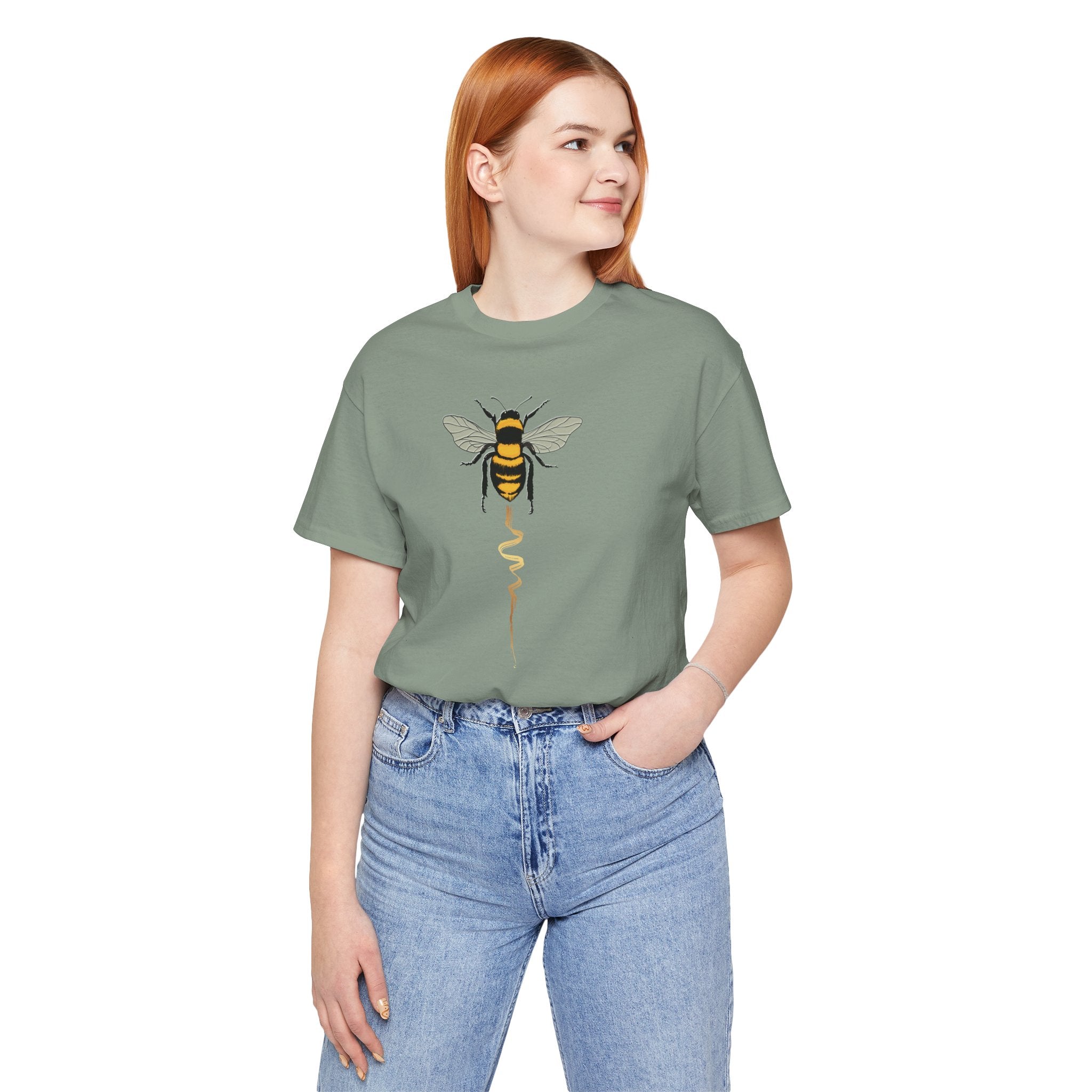 Person wearing a green t-shirt with a bee design on a white background