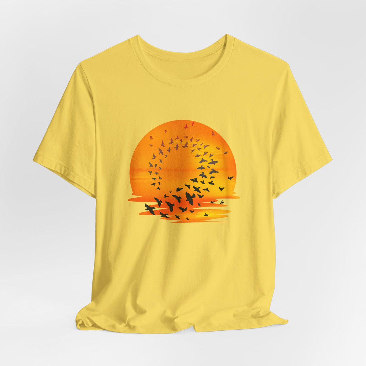 Yellow t-shirt with a sunset and bird design on a white background