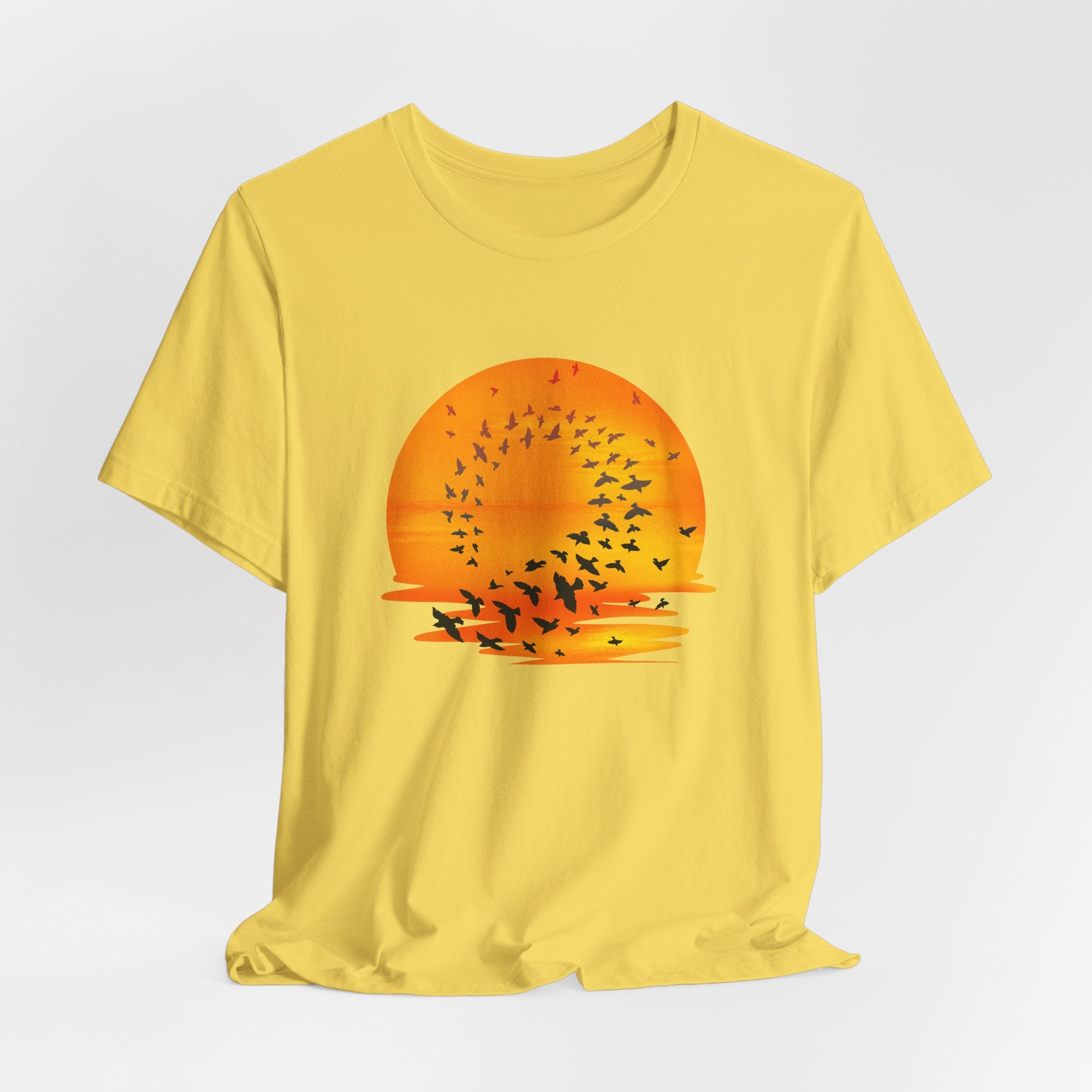 Yellow t-shirt with a sunset and bird design on a white background