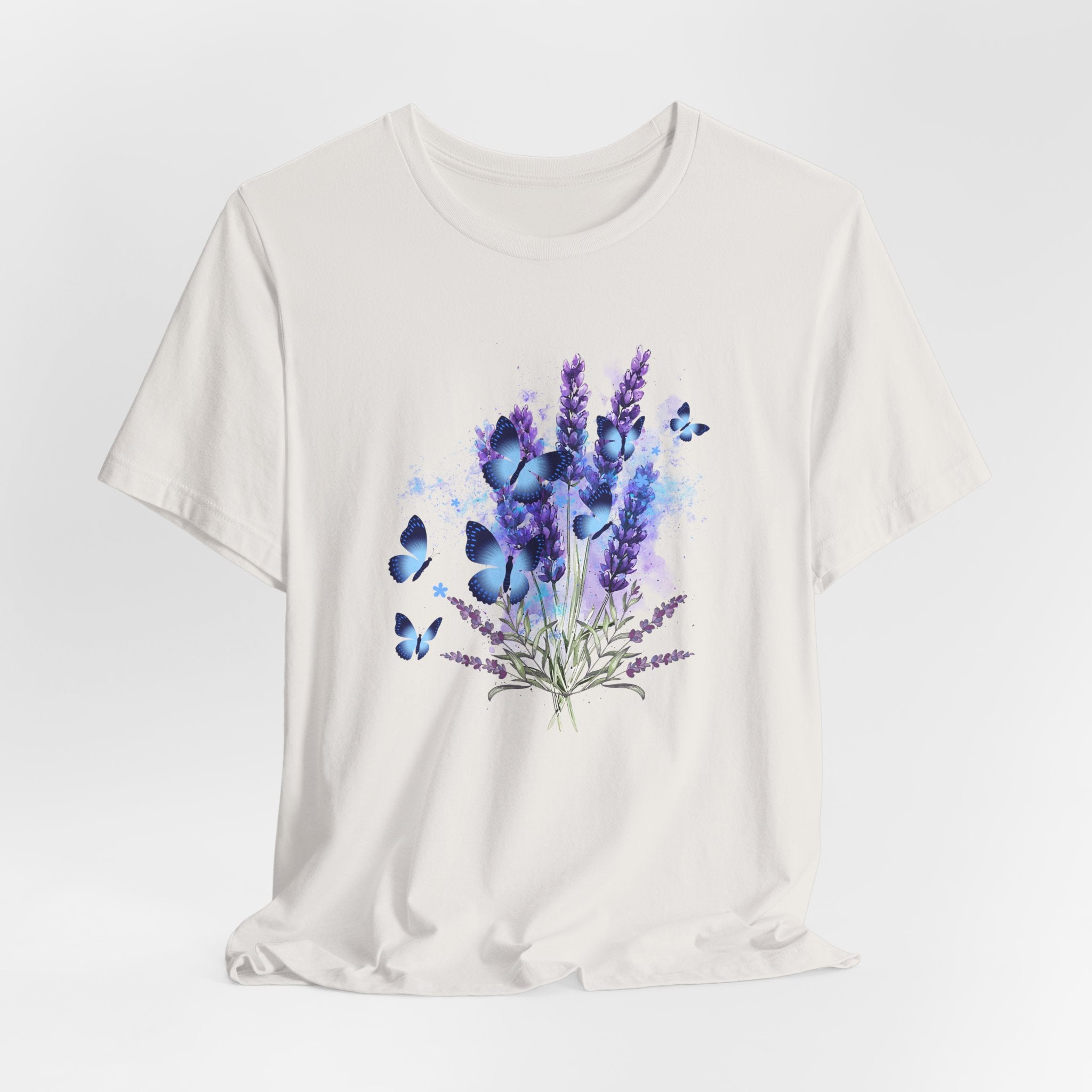 White t-shirt with a floral and butterfly design on a light gray background
