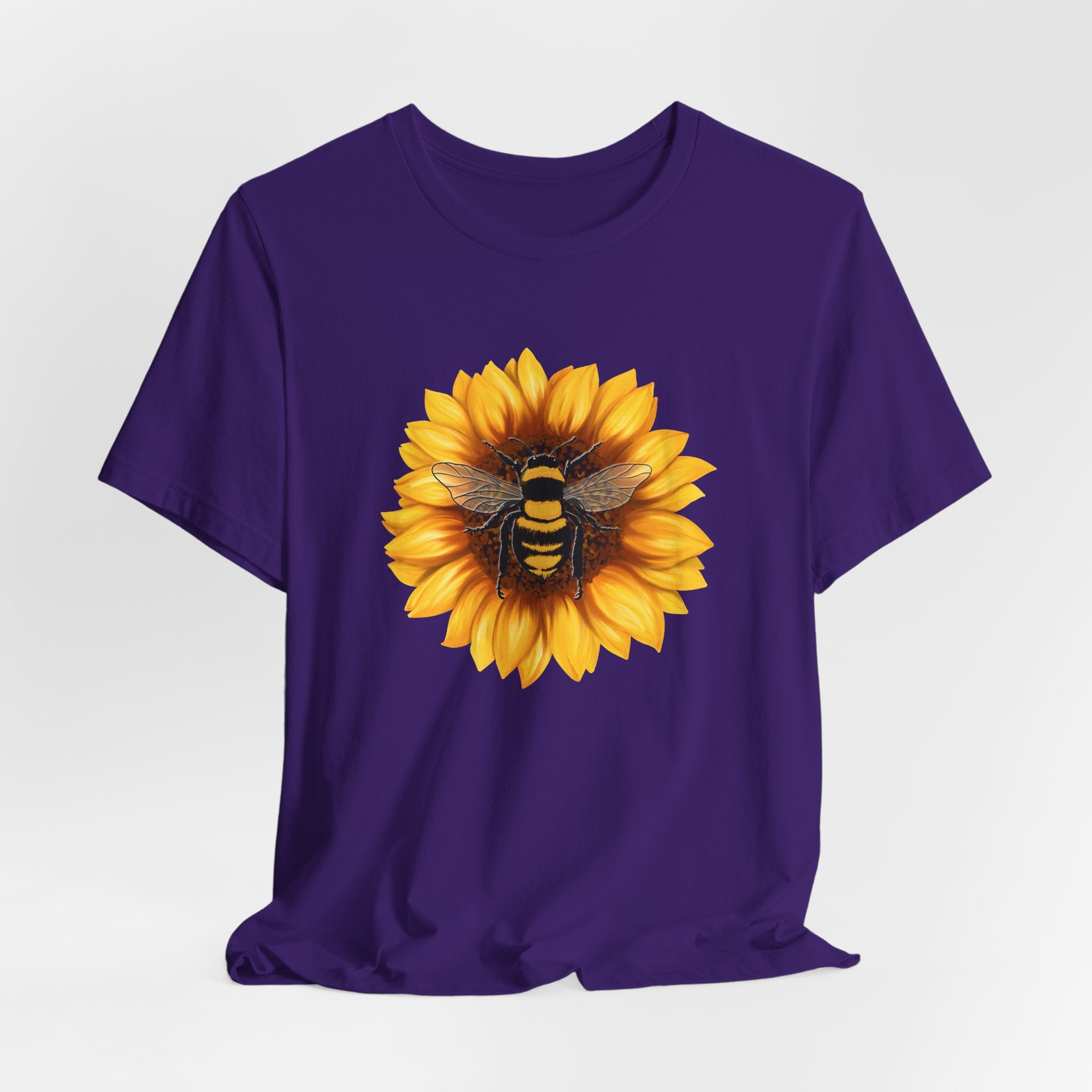 Purple t-shirt with a sunflower and bee design on a white background