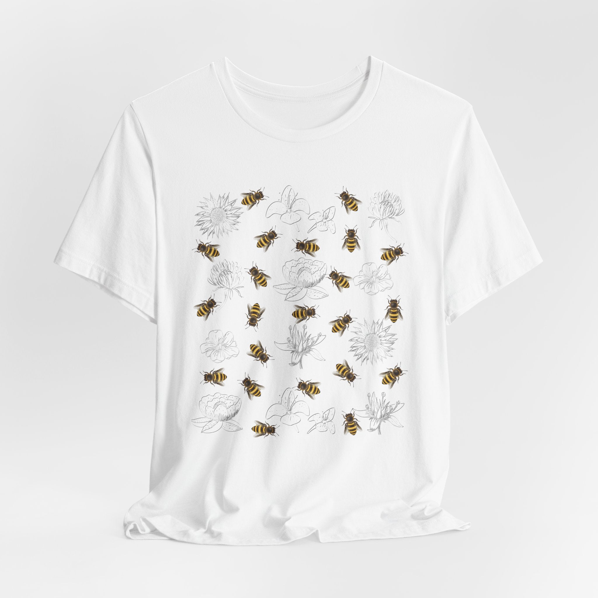 White t-shirt with bee and flower pattern on a light gray background