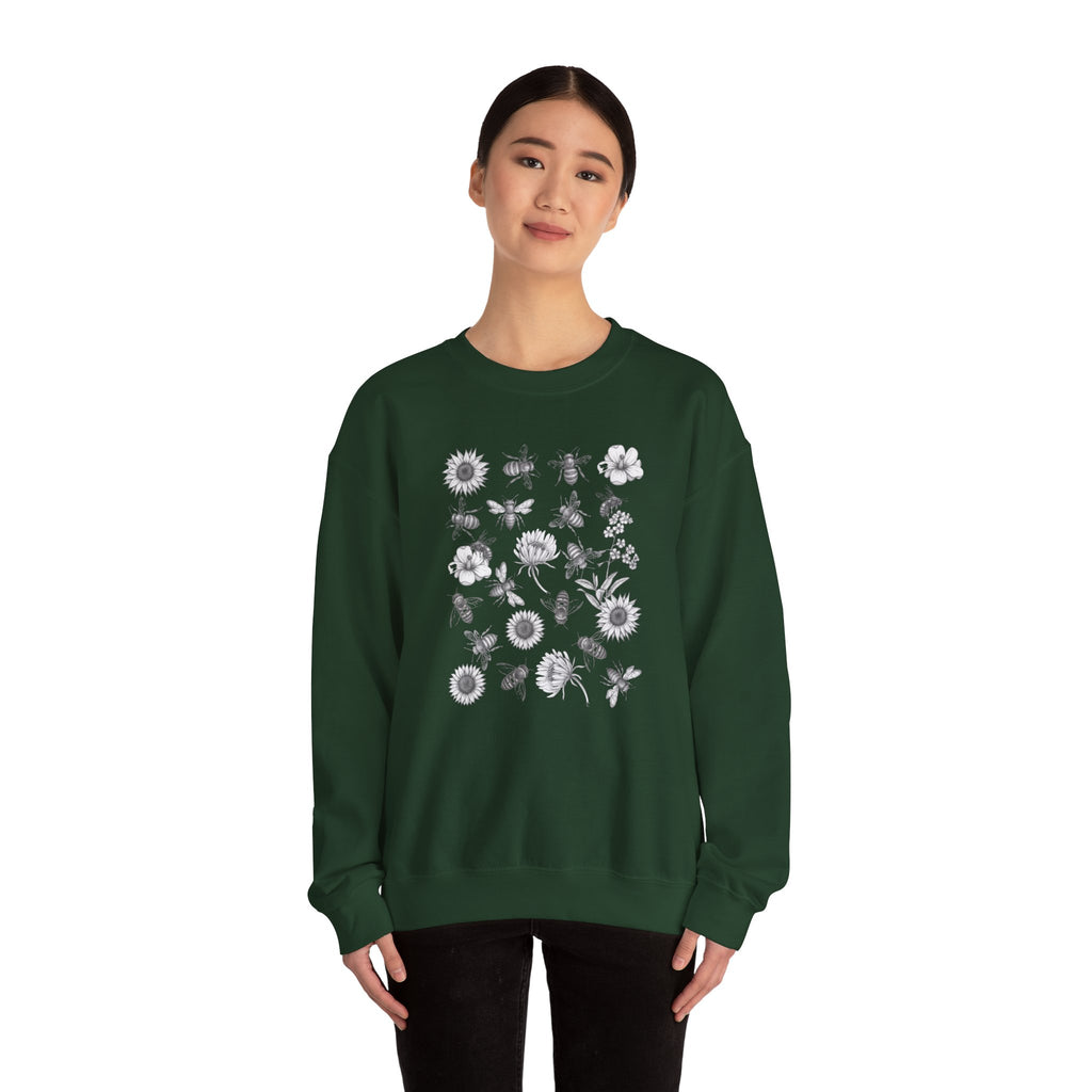Person wearing a green sweatshirt with bee and flower pattern on a white background