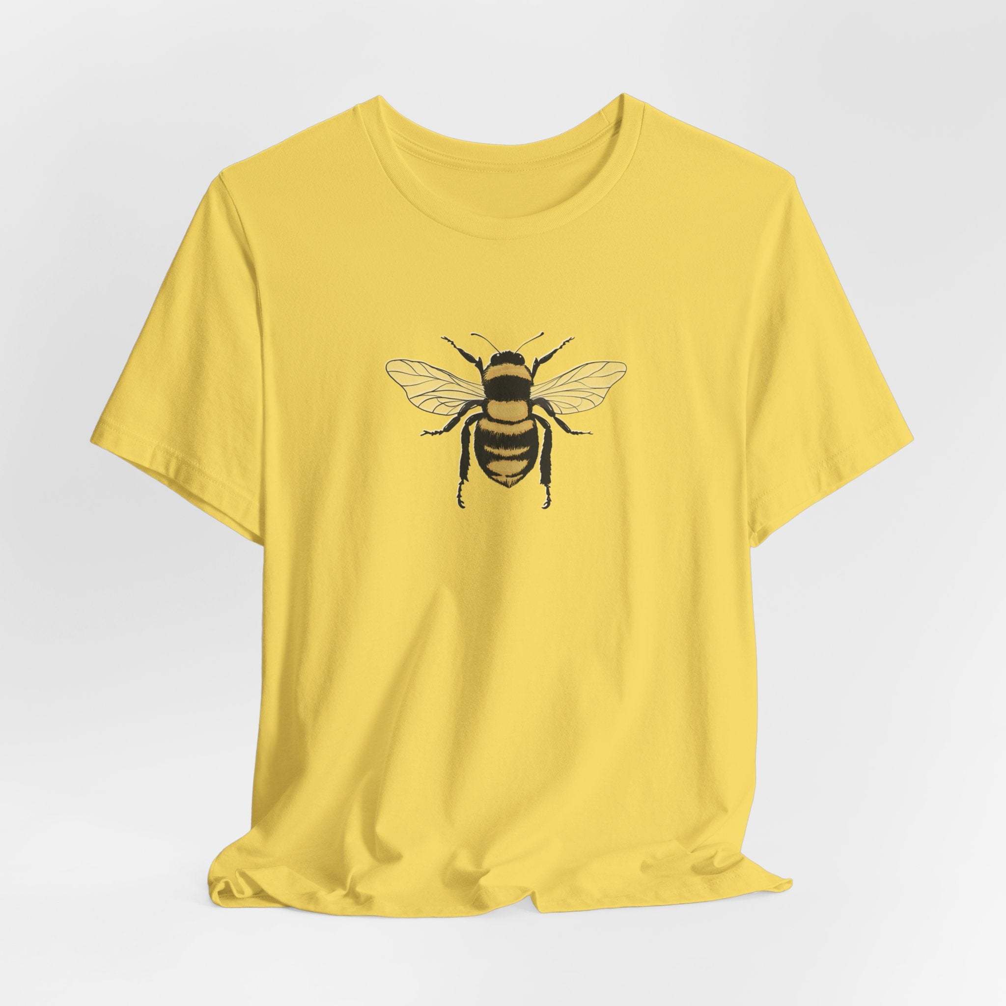 Yellow t-shirt with a bee design on a light gray background