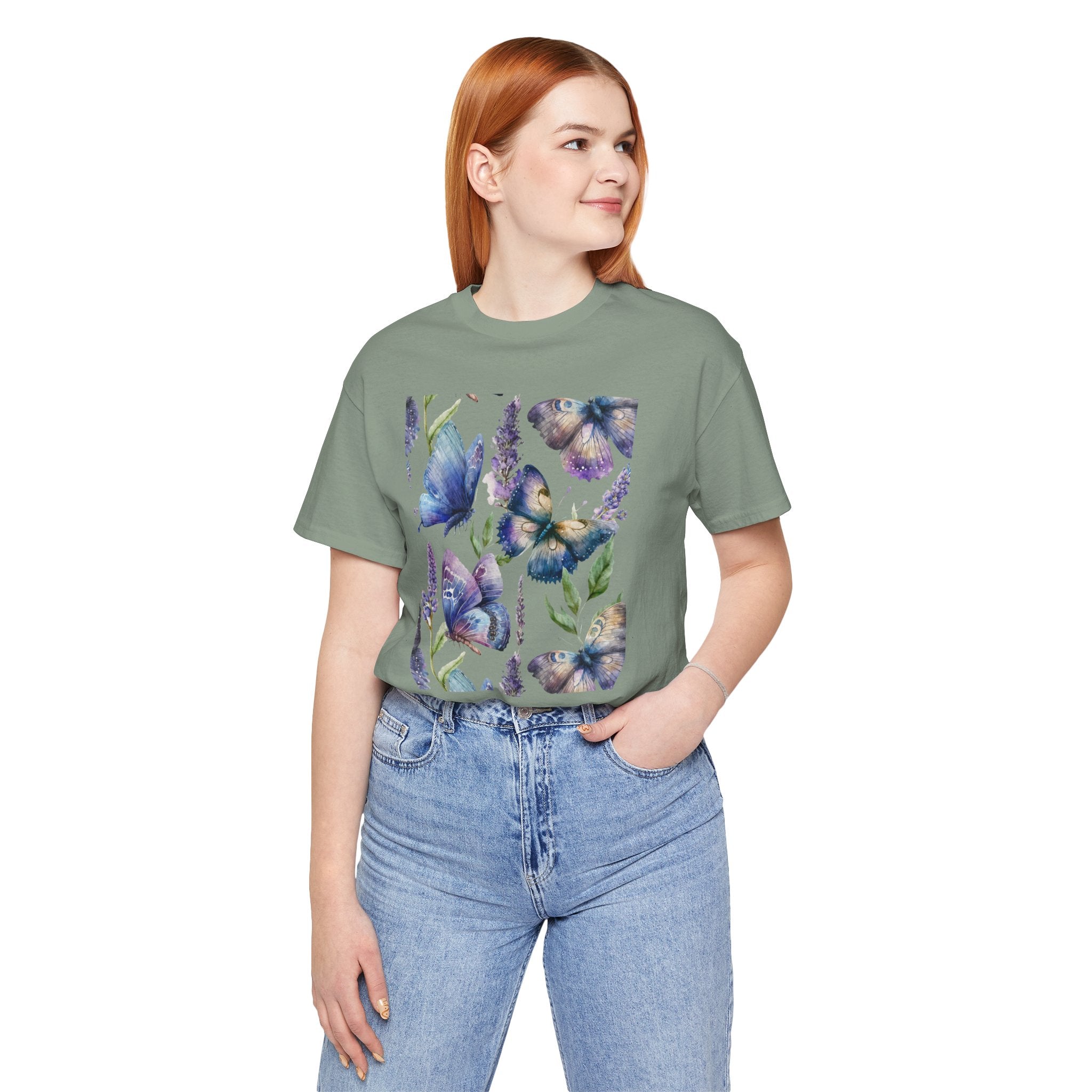 Person wearing a green t-shirt with butterfly design and blue jeans on a white background