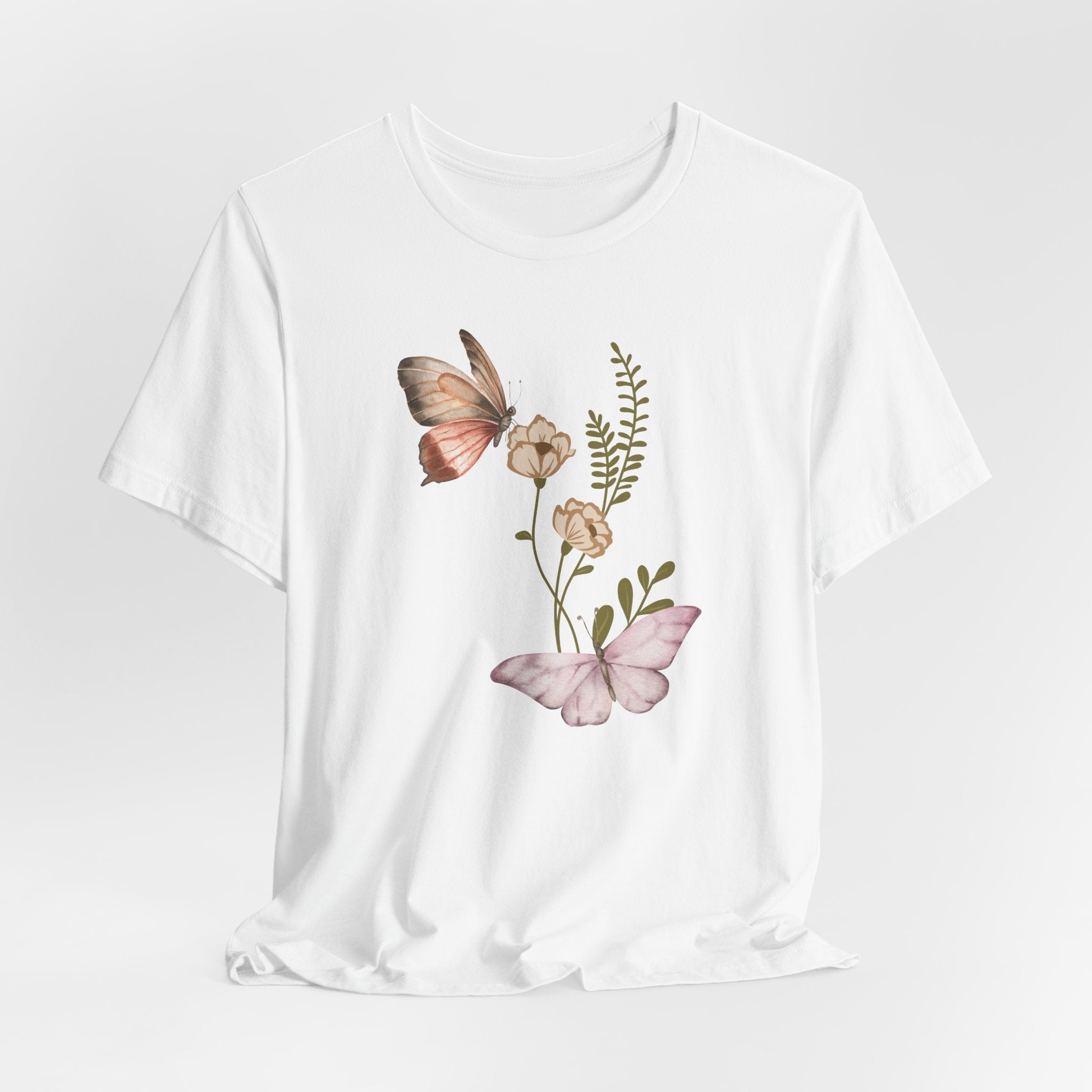 White t-shirt with butterfly and floral design on a light gray background