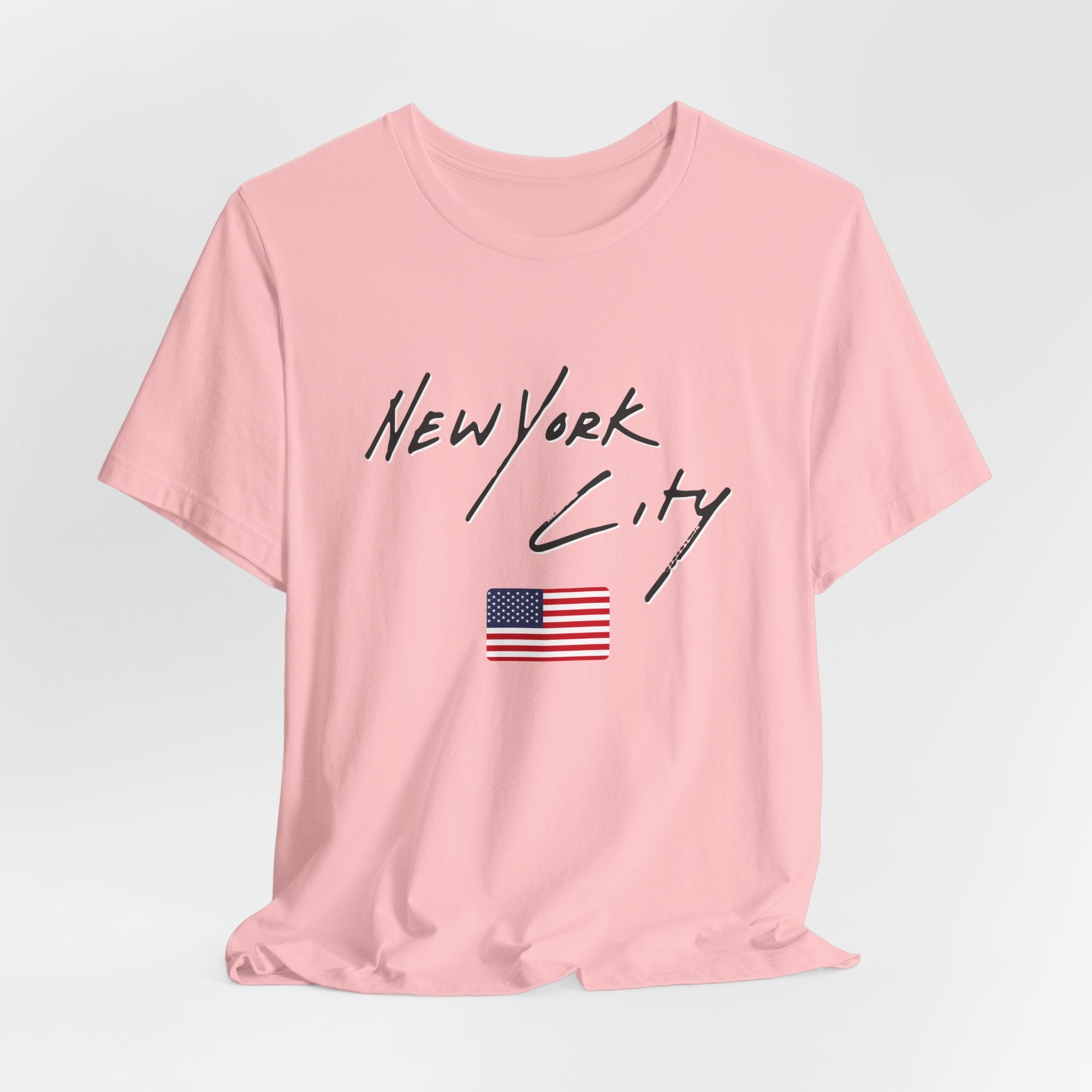 Pink t-shirt with 'New York City' text and American flag on a light gray background