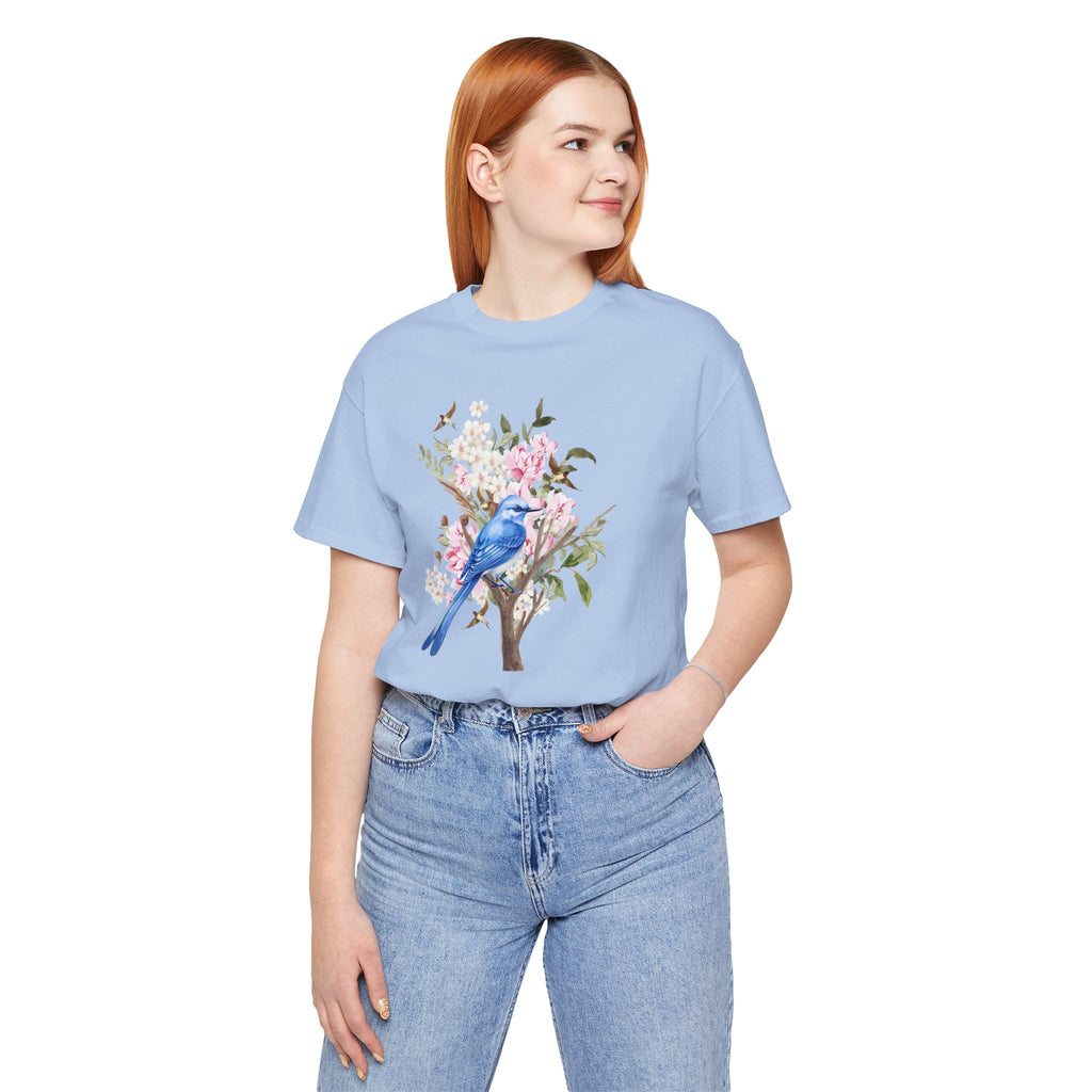 Person wearing a light blue t-shirt with a floral and bird design on a white background