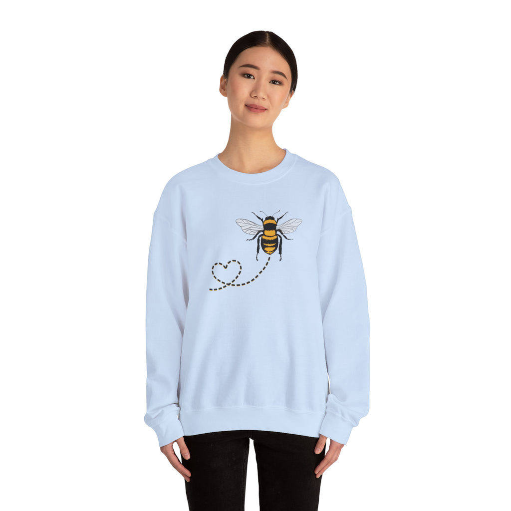 Light blue sweatshirt with bee design worn by a person on a white background