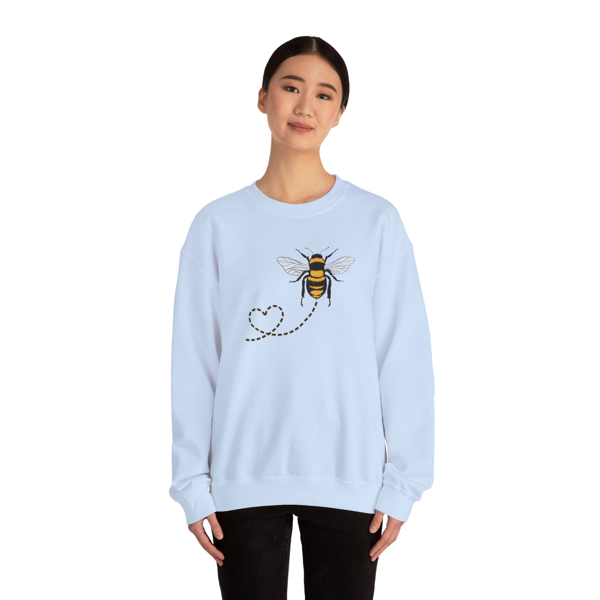Light blue sweatshirt with bee design worn by a person on a white background