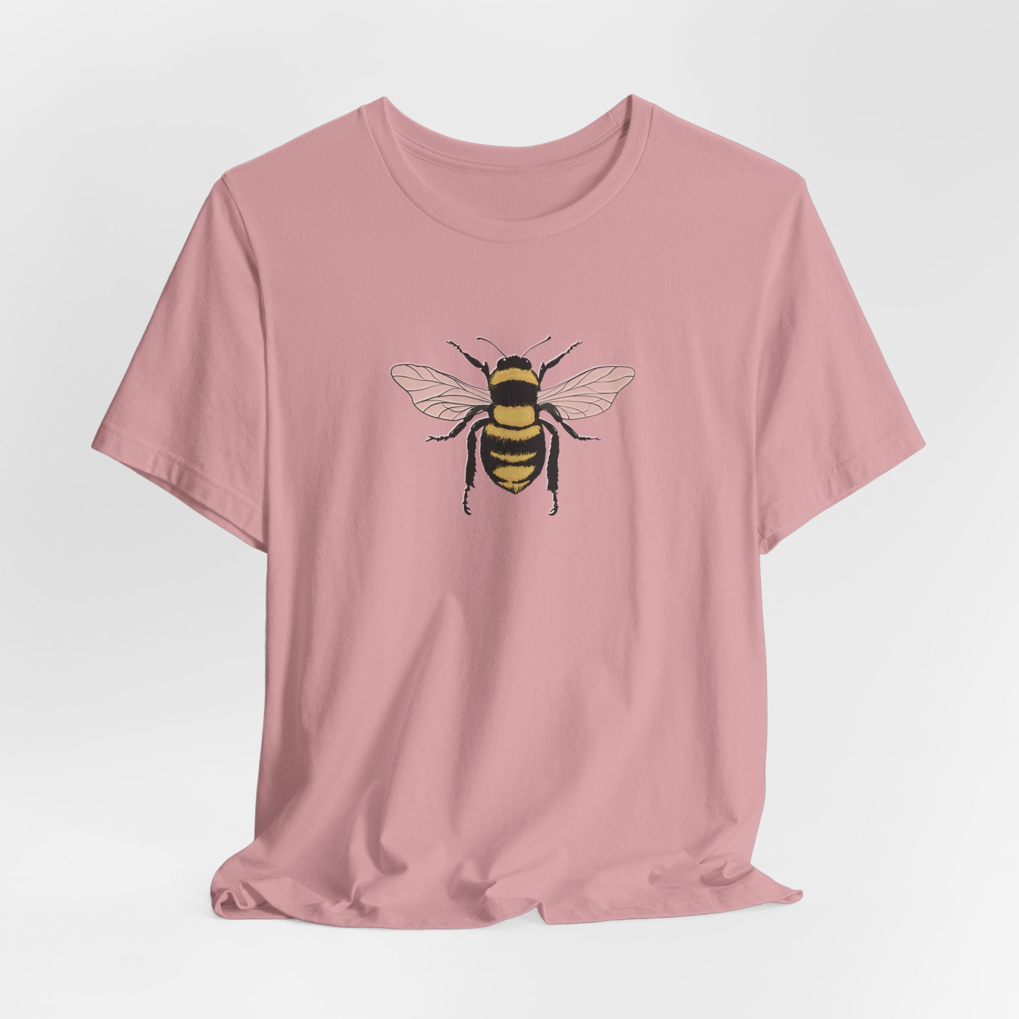 Pink t-shirt with a bee graphic on a light gray background