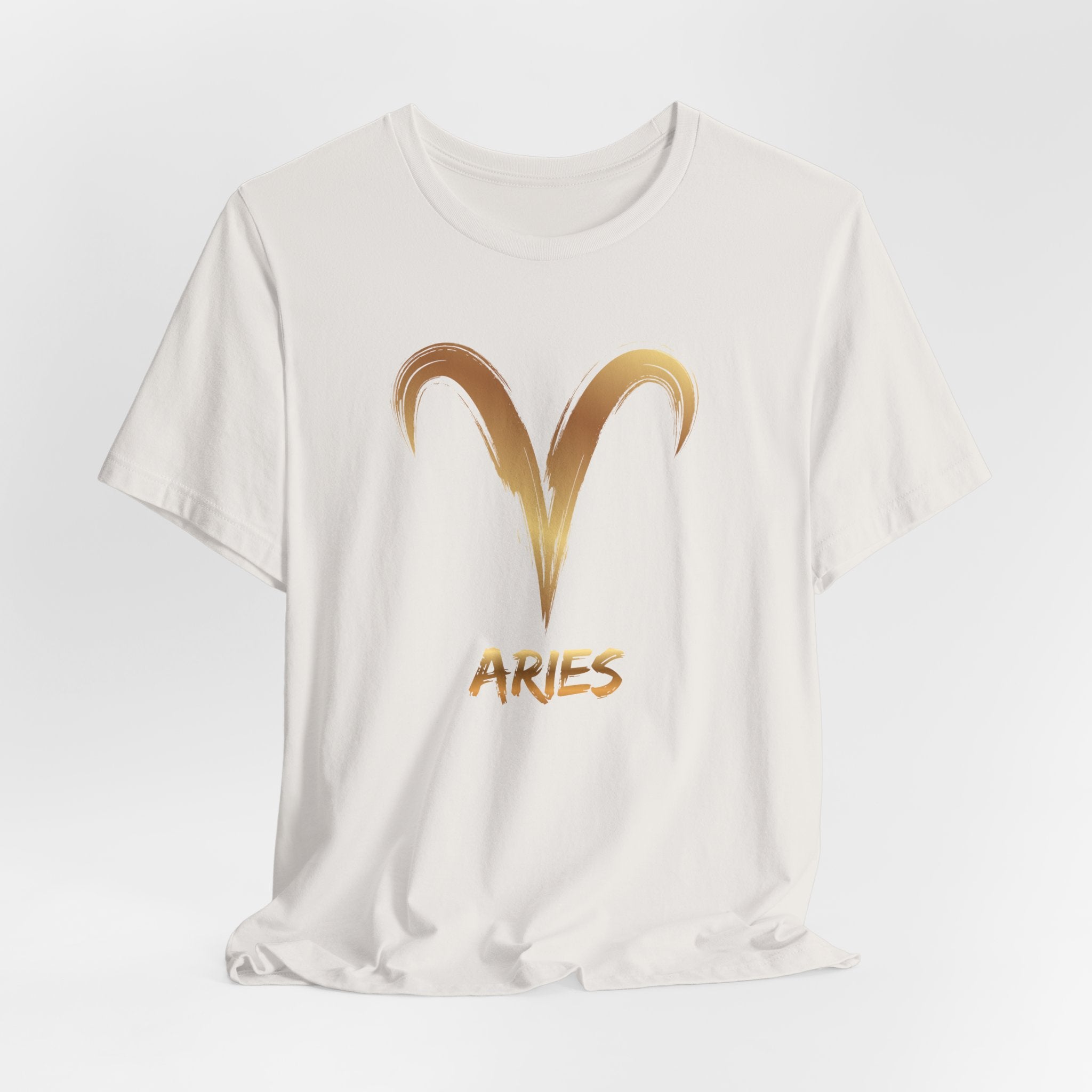 White t-shirt with gold Aries symbol and text on a light gray background