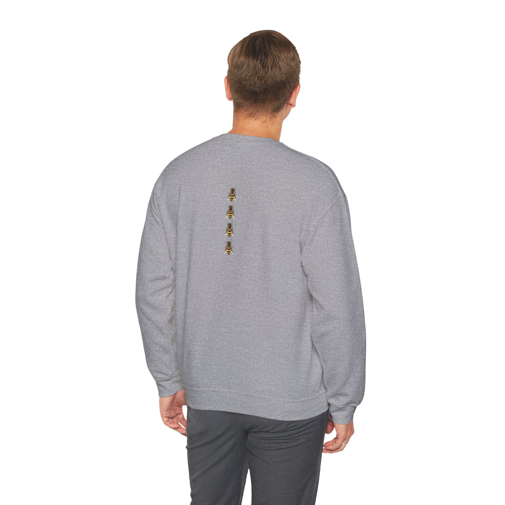 Man wearing a gray sweatshirt with a small bee logo on a white background