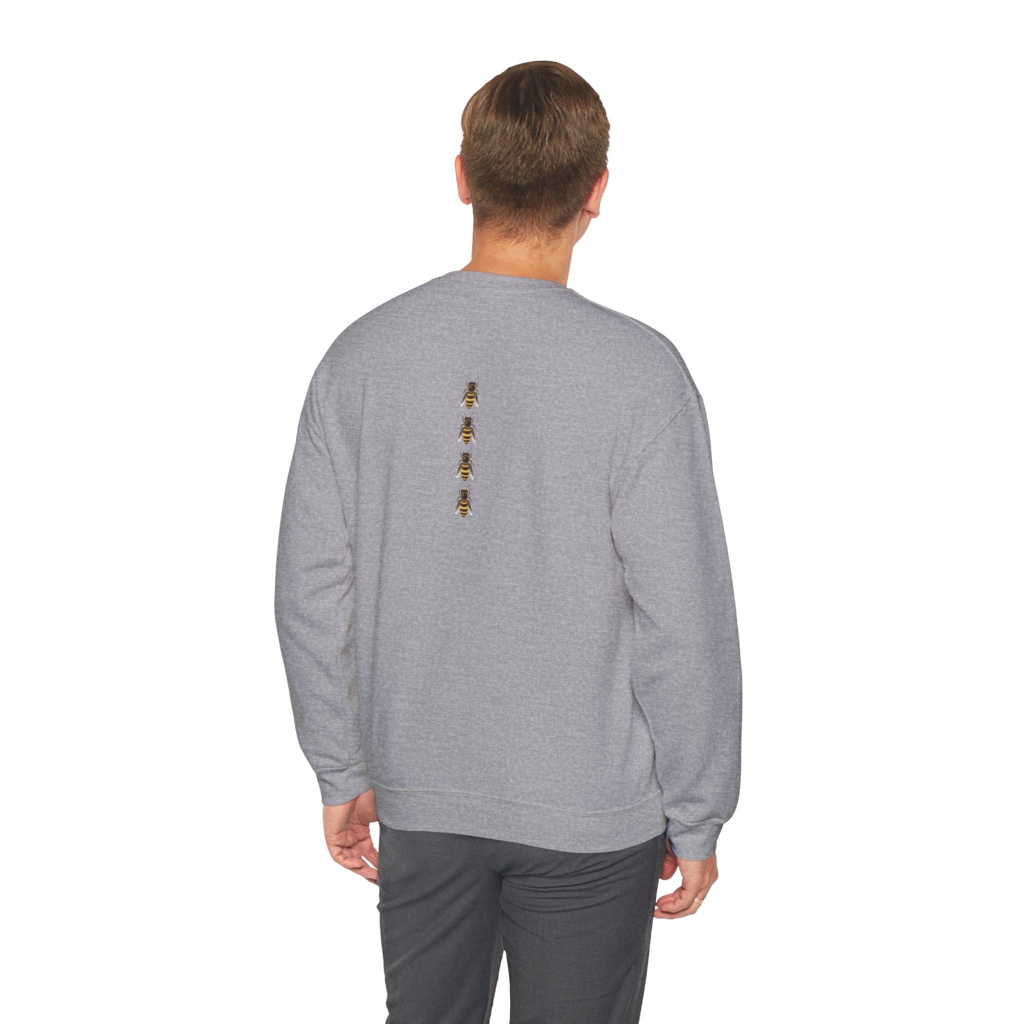 Man wearing a gray sweatshirt with a small bee logo on a white background