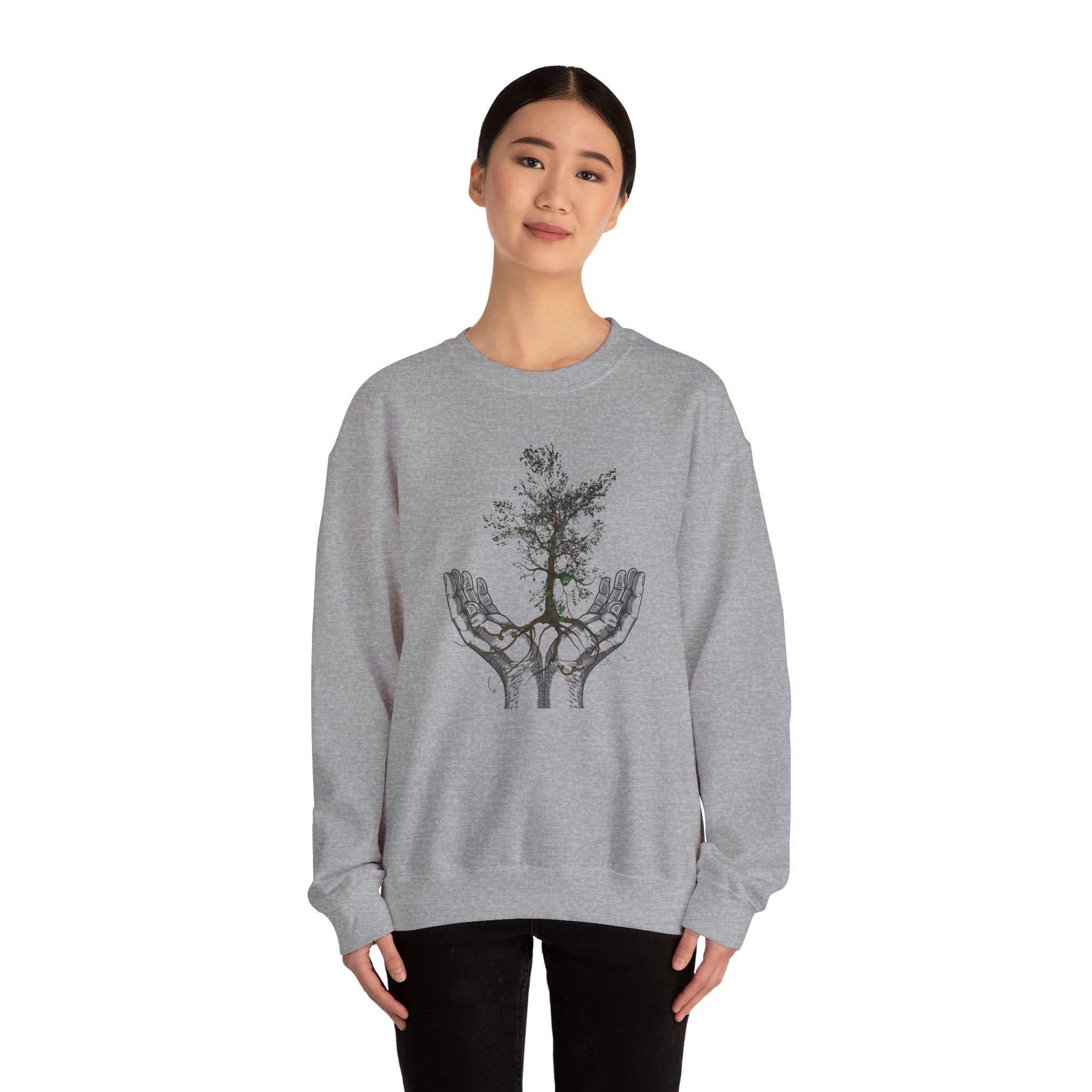 Person wearing a gray sweatshirt with a tree design on a white background