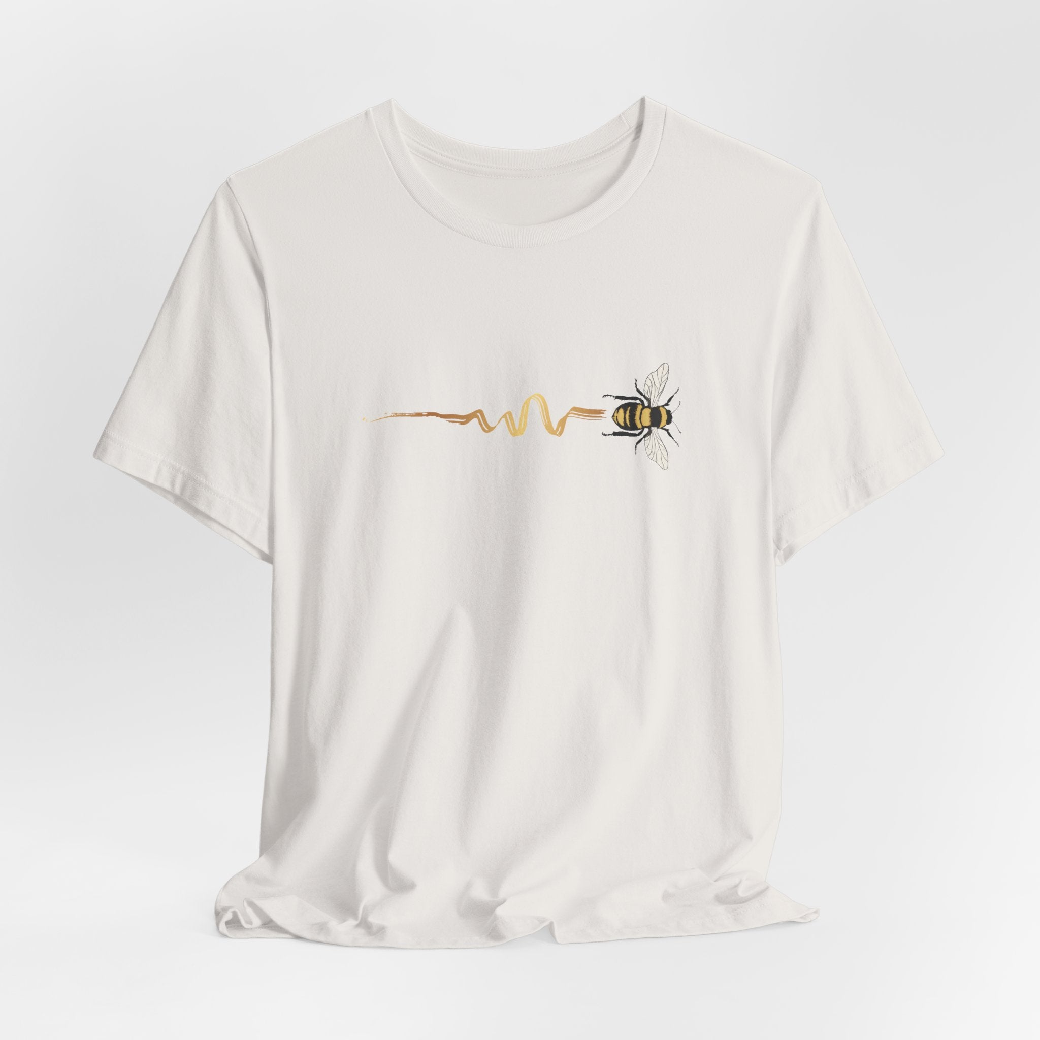 White t-shirt with a bee and pulse line design on a light gray background