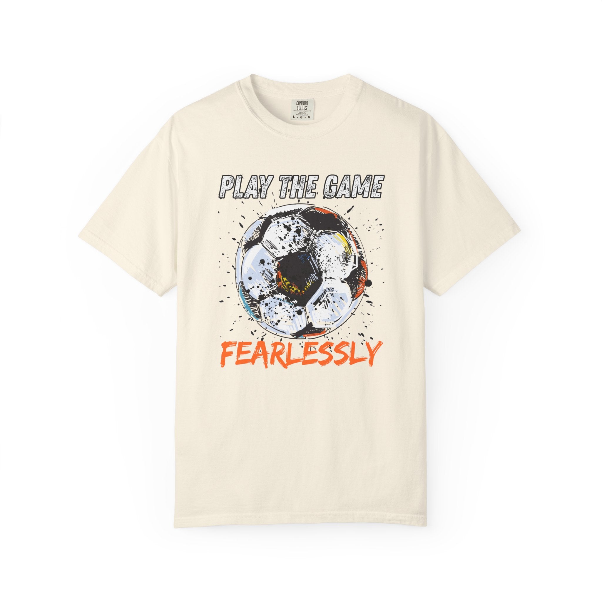 Beige t-shirt with dirty soccer ball graphic and play the game fearlessly text on a white background