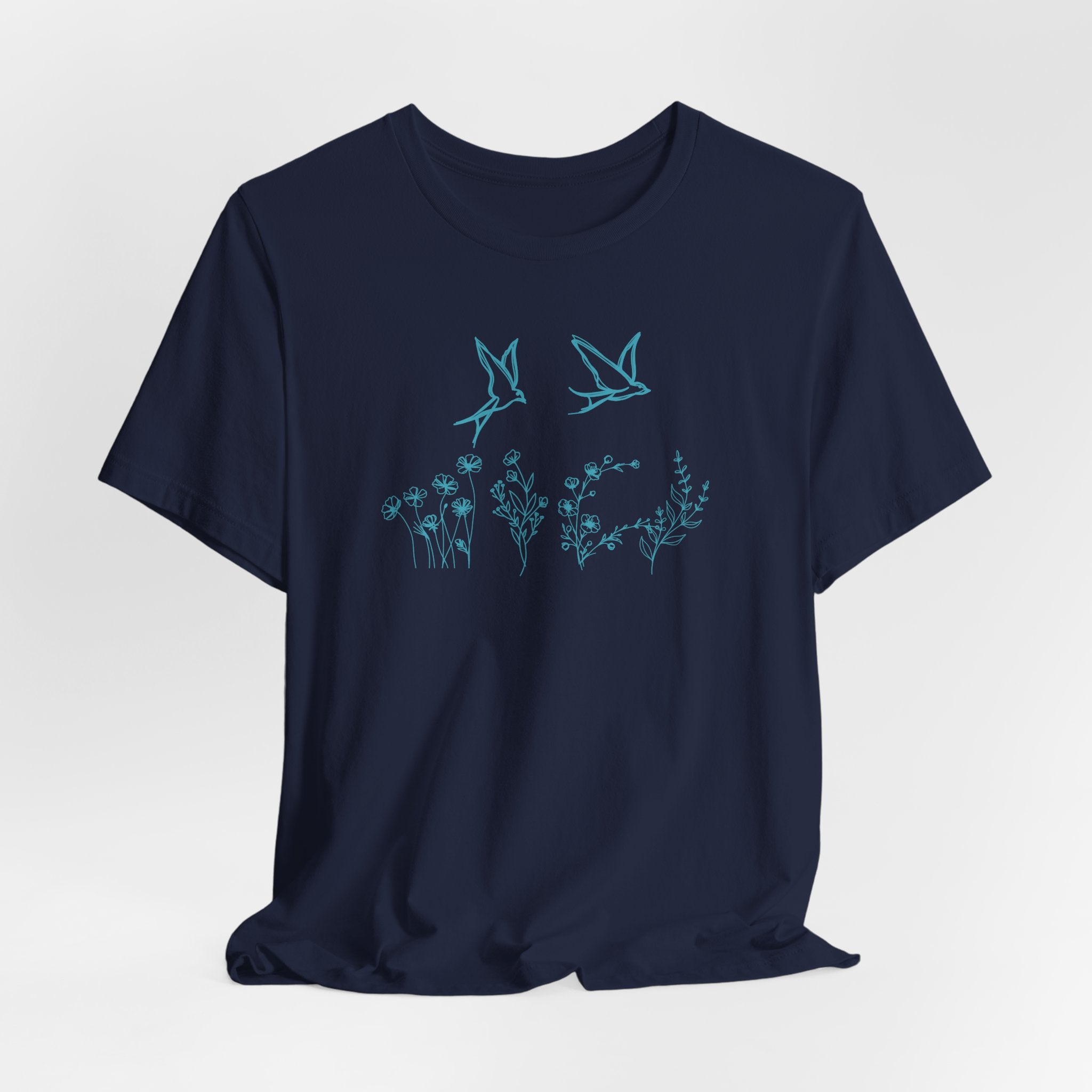 Navy blue t-shirt with teal bird and floral design on a light gray background