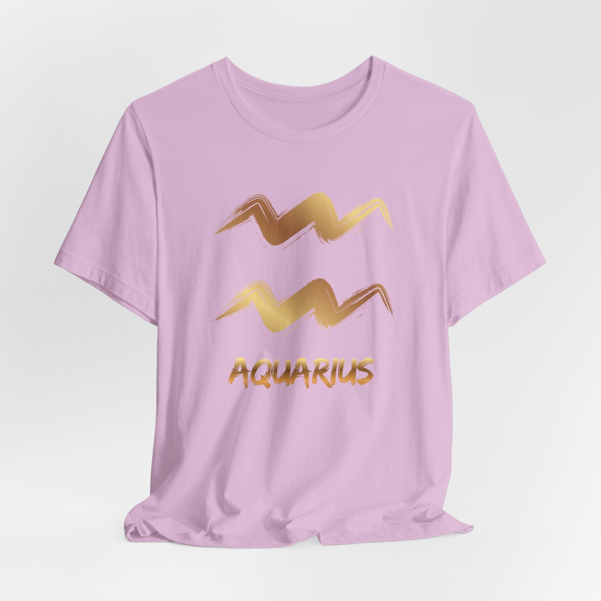 Pink t-shirt with gold Aquarius zodiac sign design on a light gray background