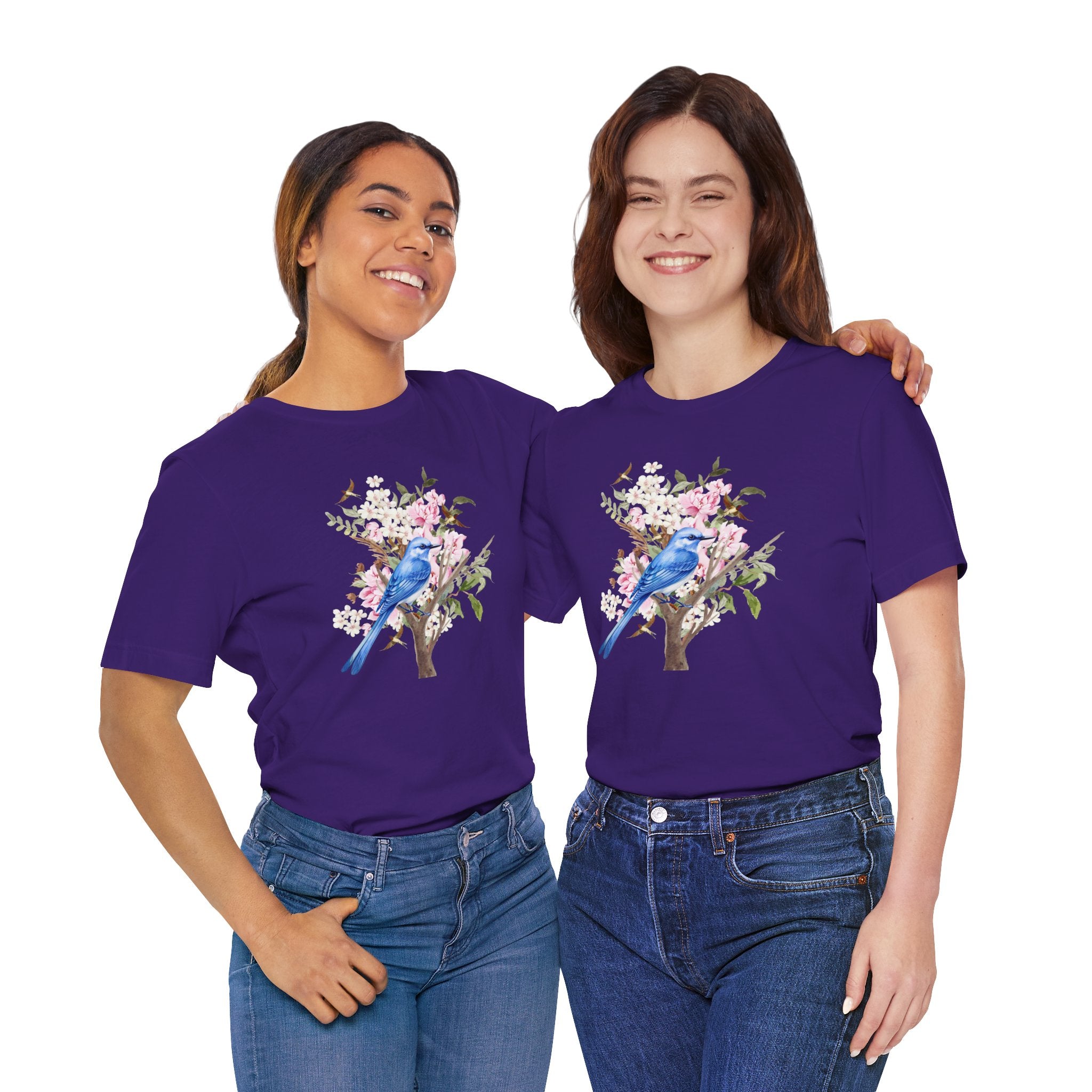 Two people wearing purple  t-shirts with a blue bird and floral design on a light gray background