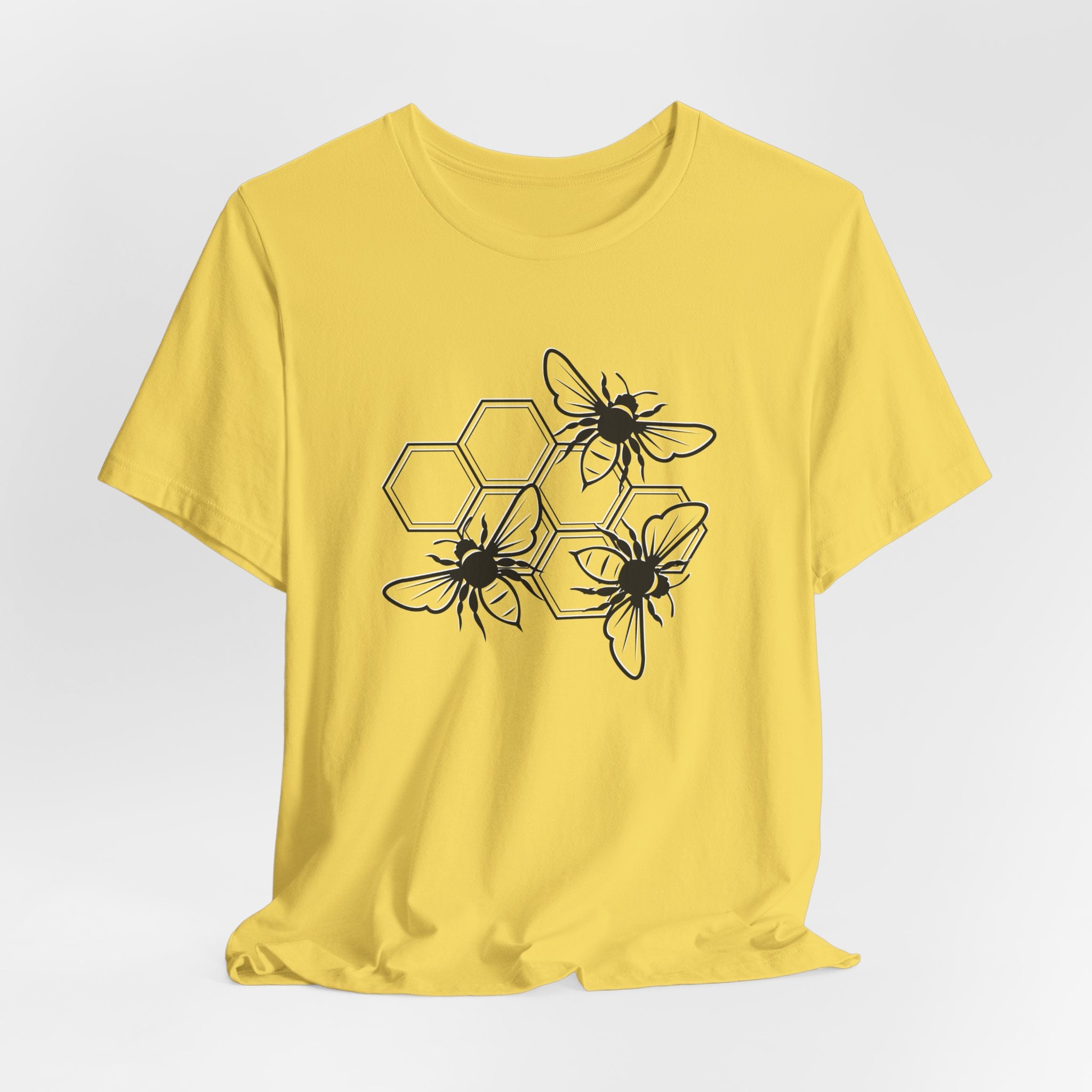Yellow t-shirt with black bee and honeycomb design on a white background