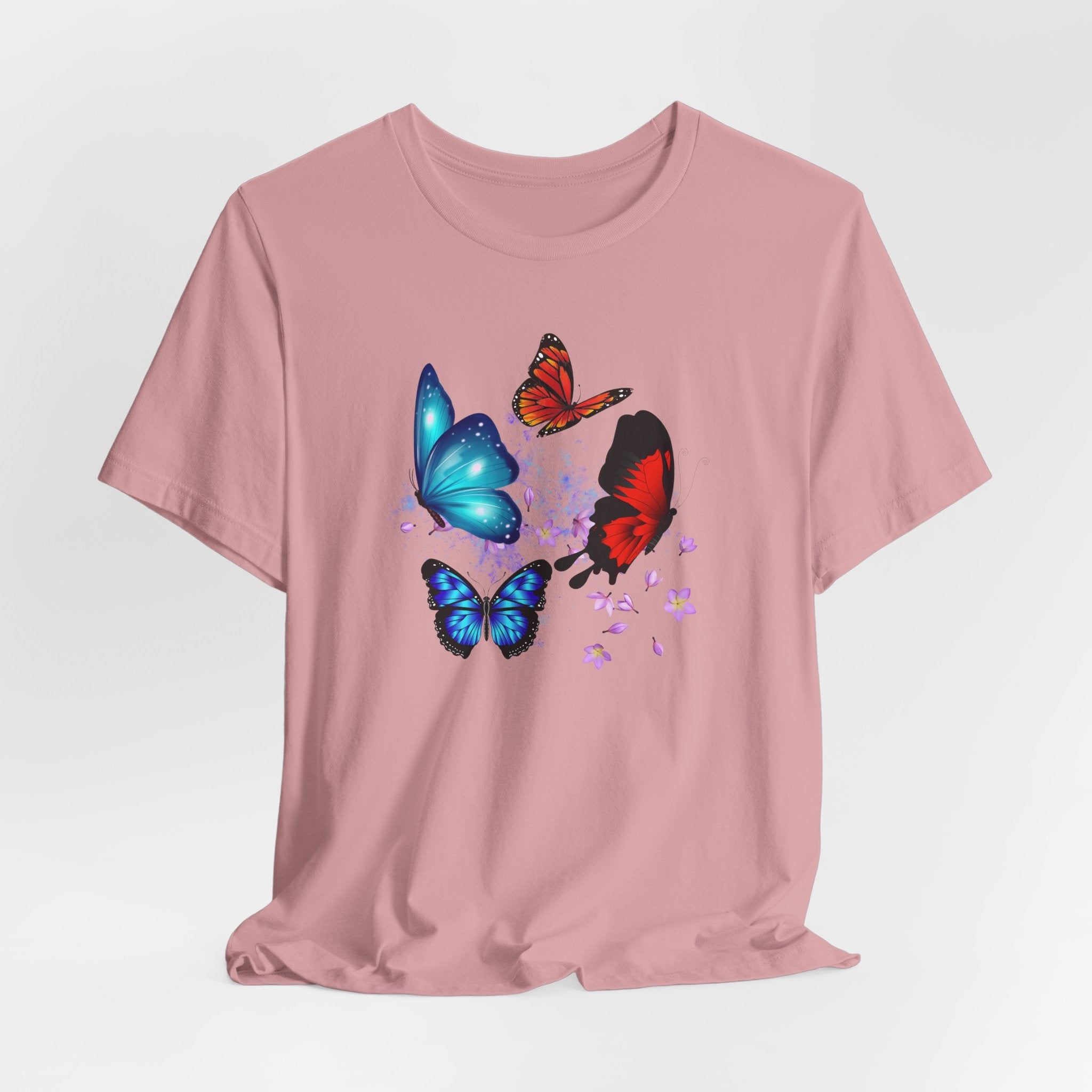 Pink t-shirt with colorful butterfly designs on a light gray background
