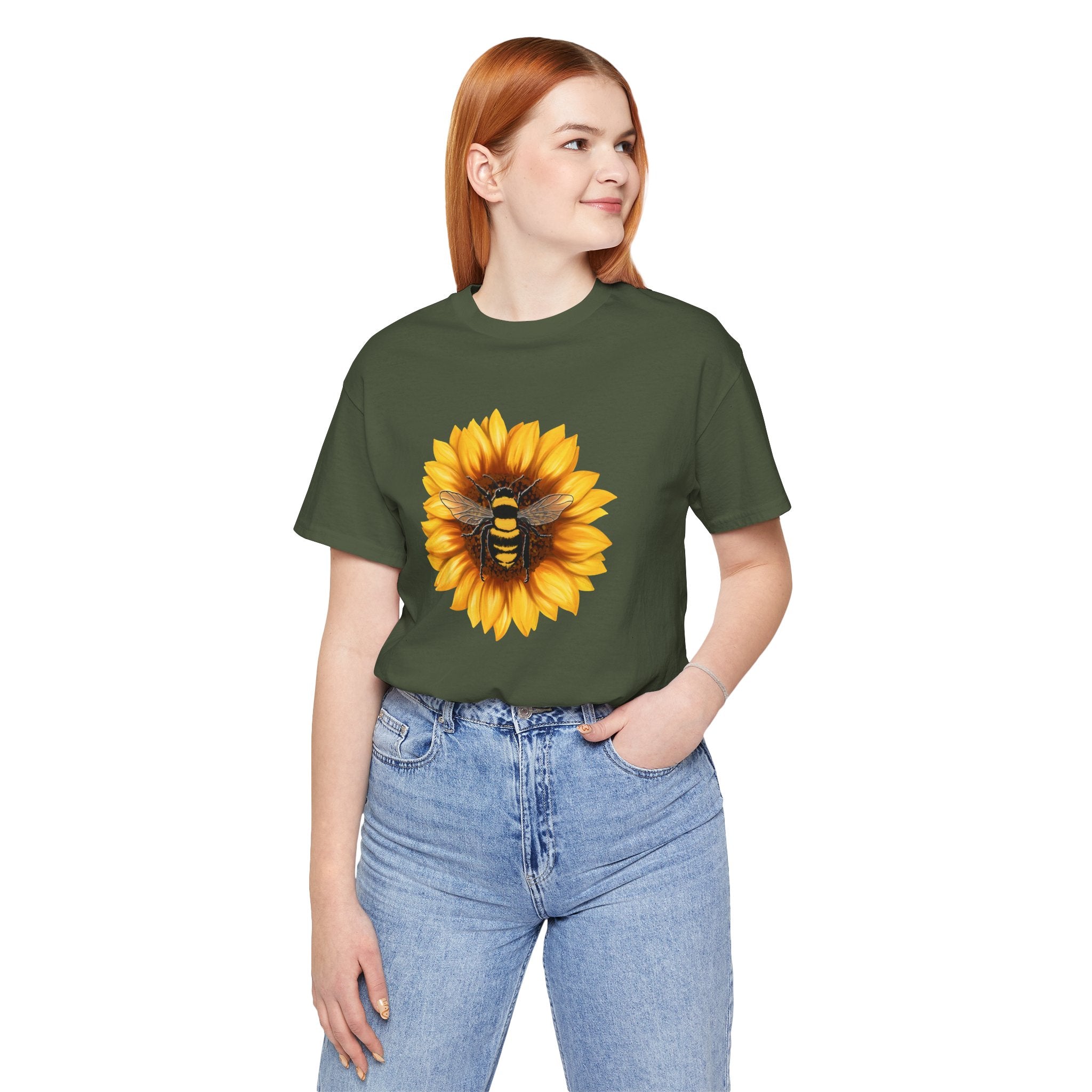 Person wearing a green t-shirt with a sunflower and bee design on a white background