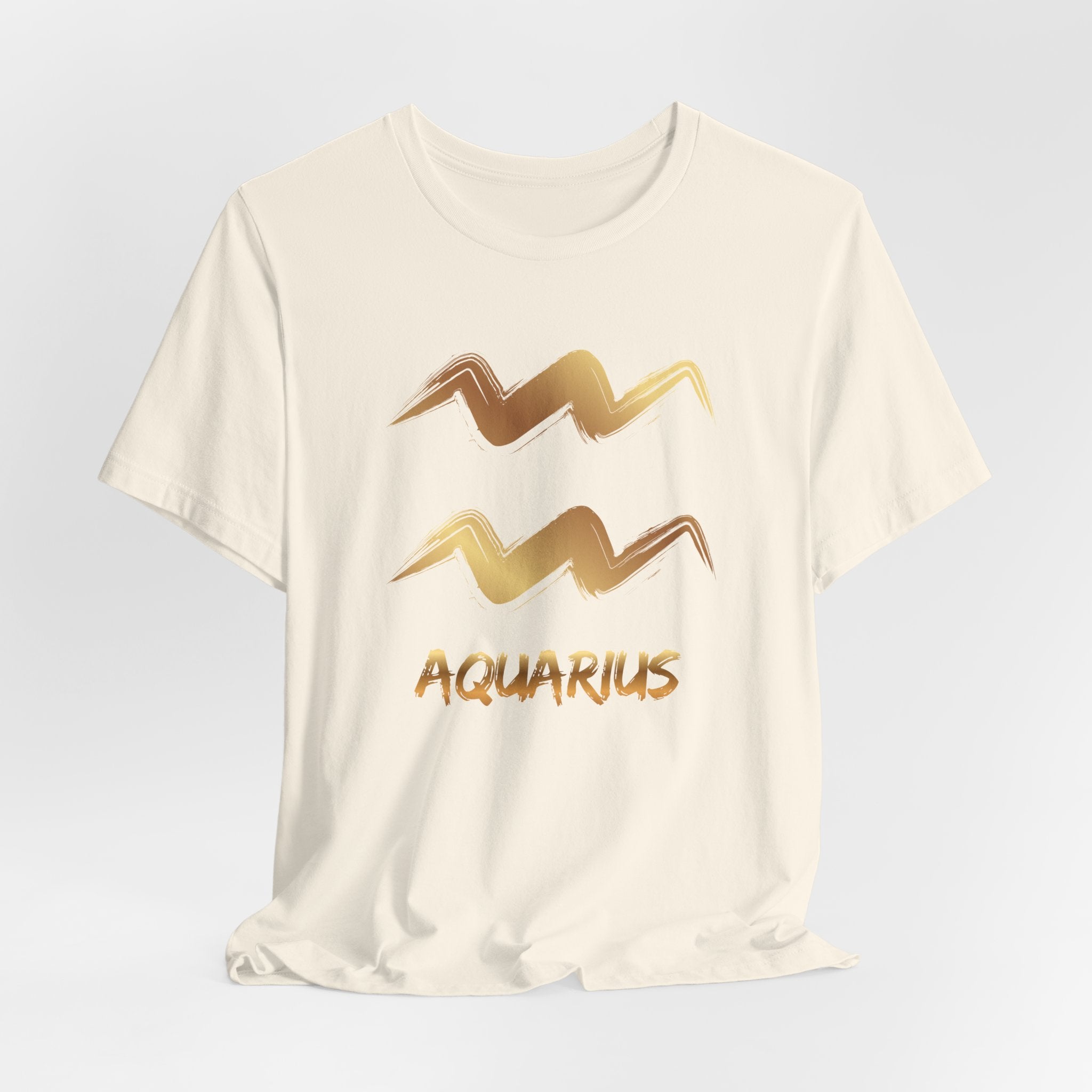 White t-shirt with gold Aquarius zodiac sign design on a light gray background