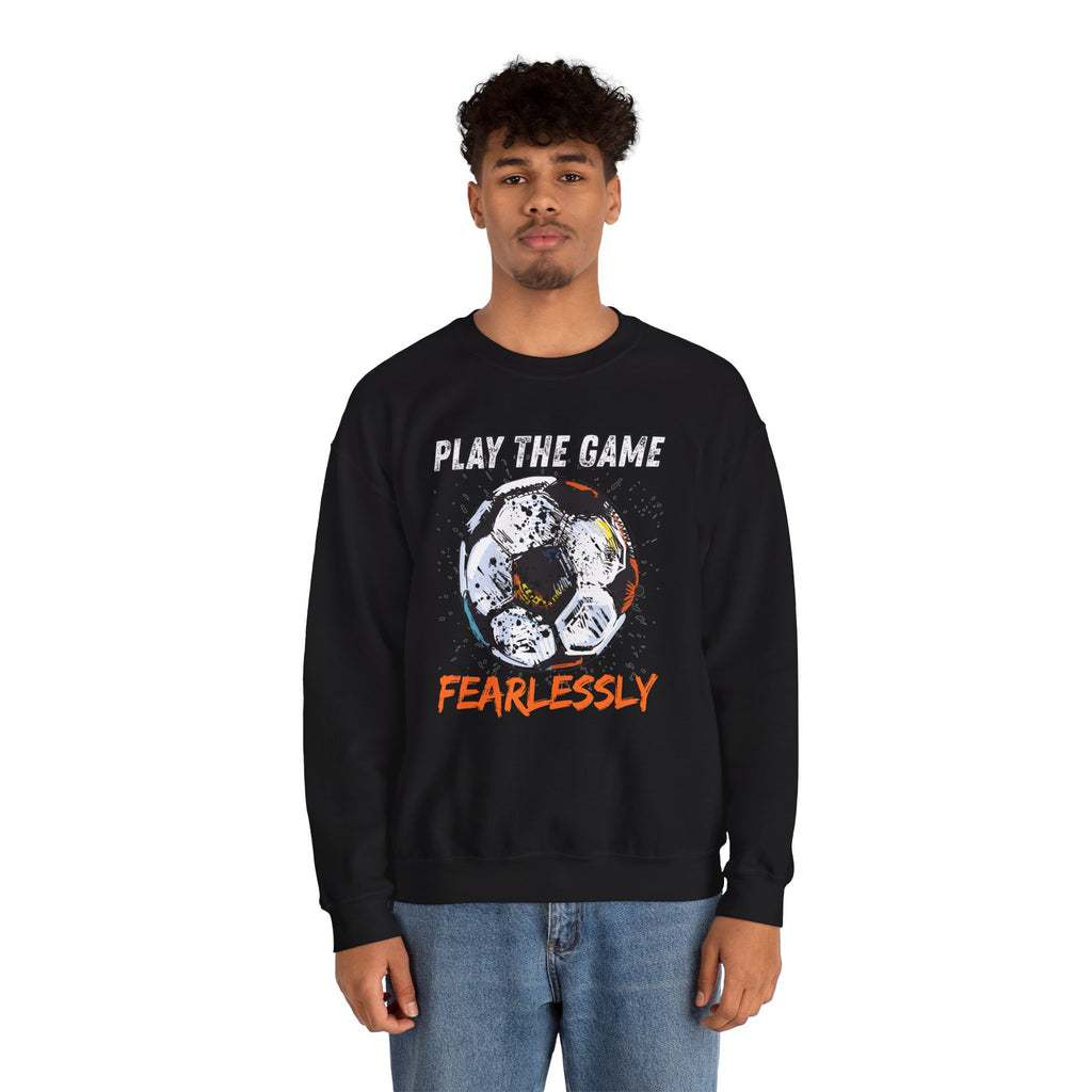 A man wearing black sweatshirt with dirty soccer ball graphic and play the game fearlessly text on a white background