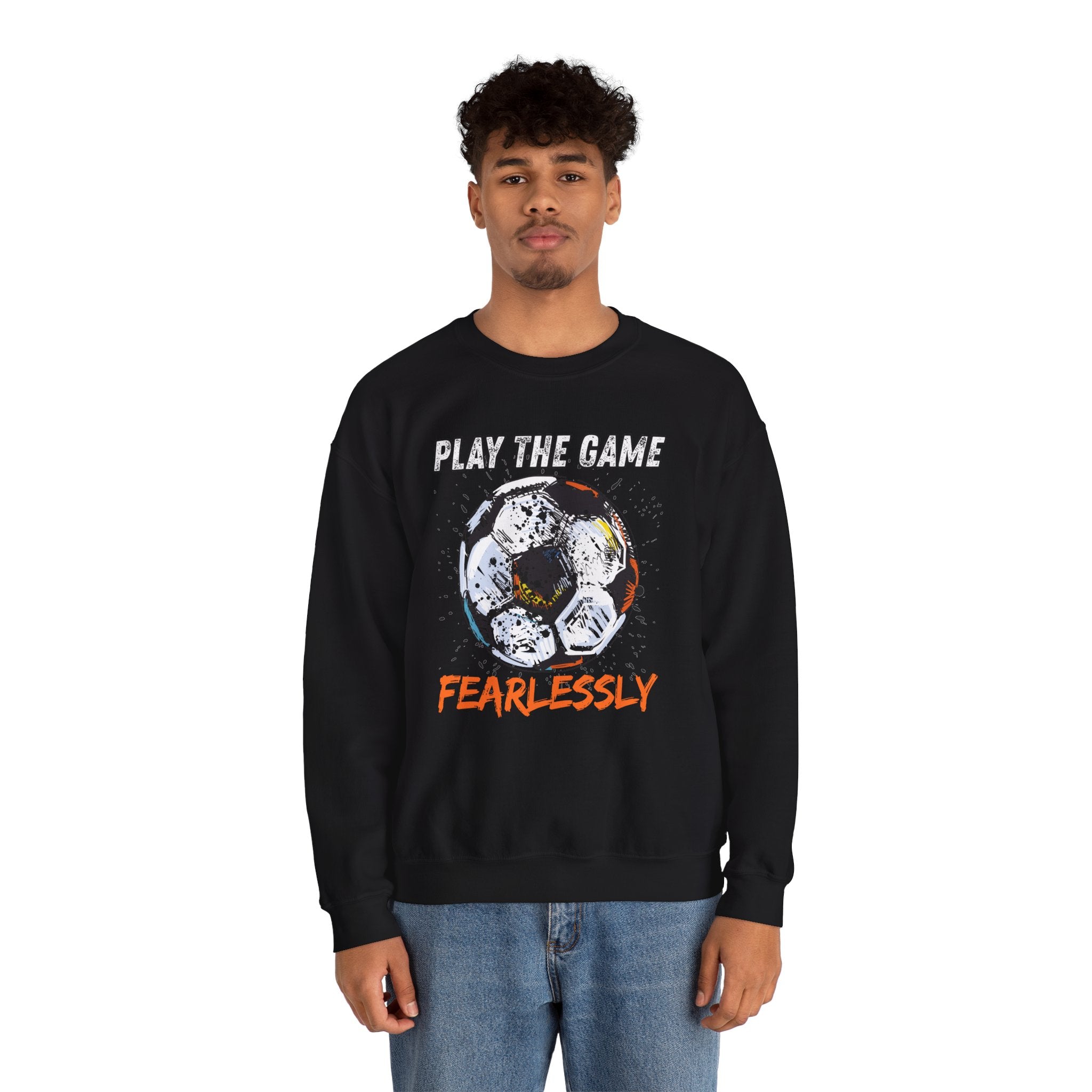 A man wearing black sweatshirt with dirty soccer ball graphic and play the game fearlessly text on a white background