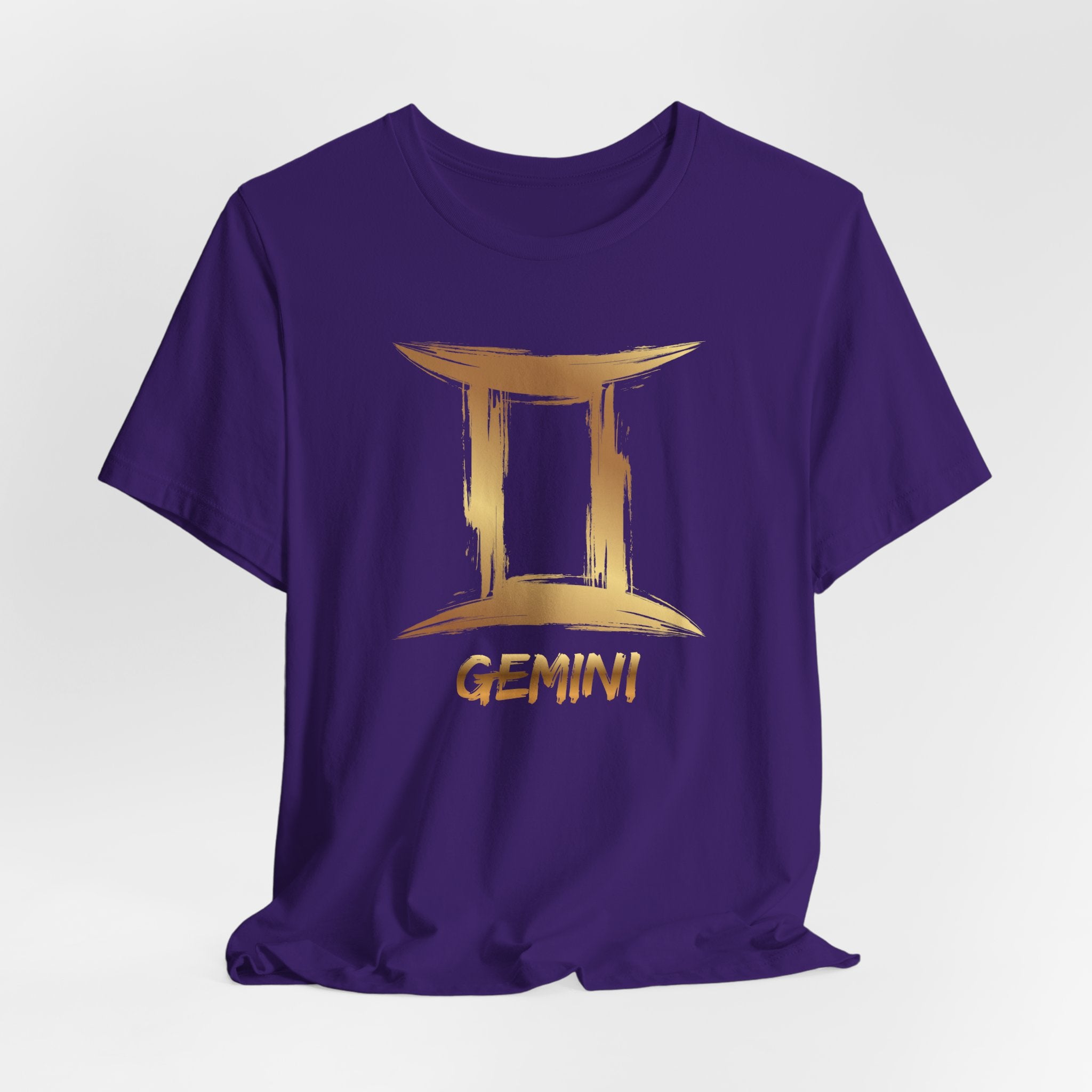 Purple t-shirt with gold Gemini zodiac symbol on a white background