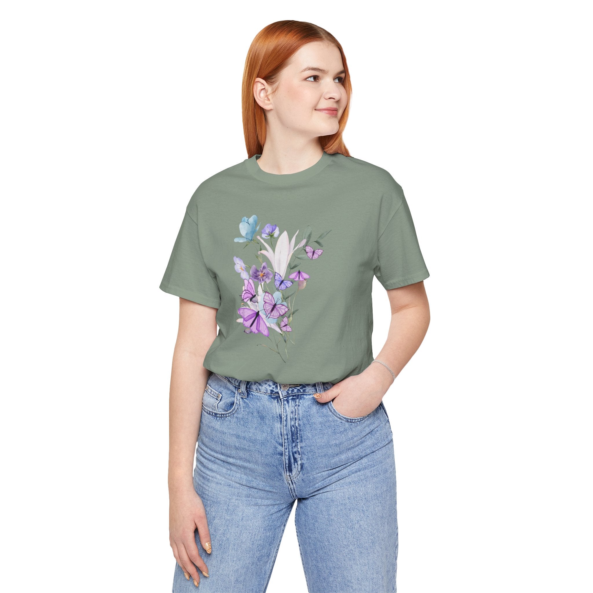 Person wearing a green t-shirt with a floral design and blue jeans on a white background