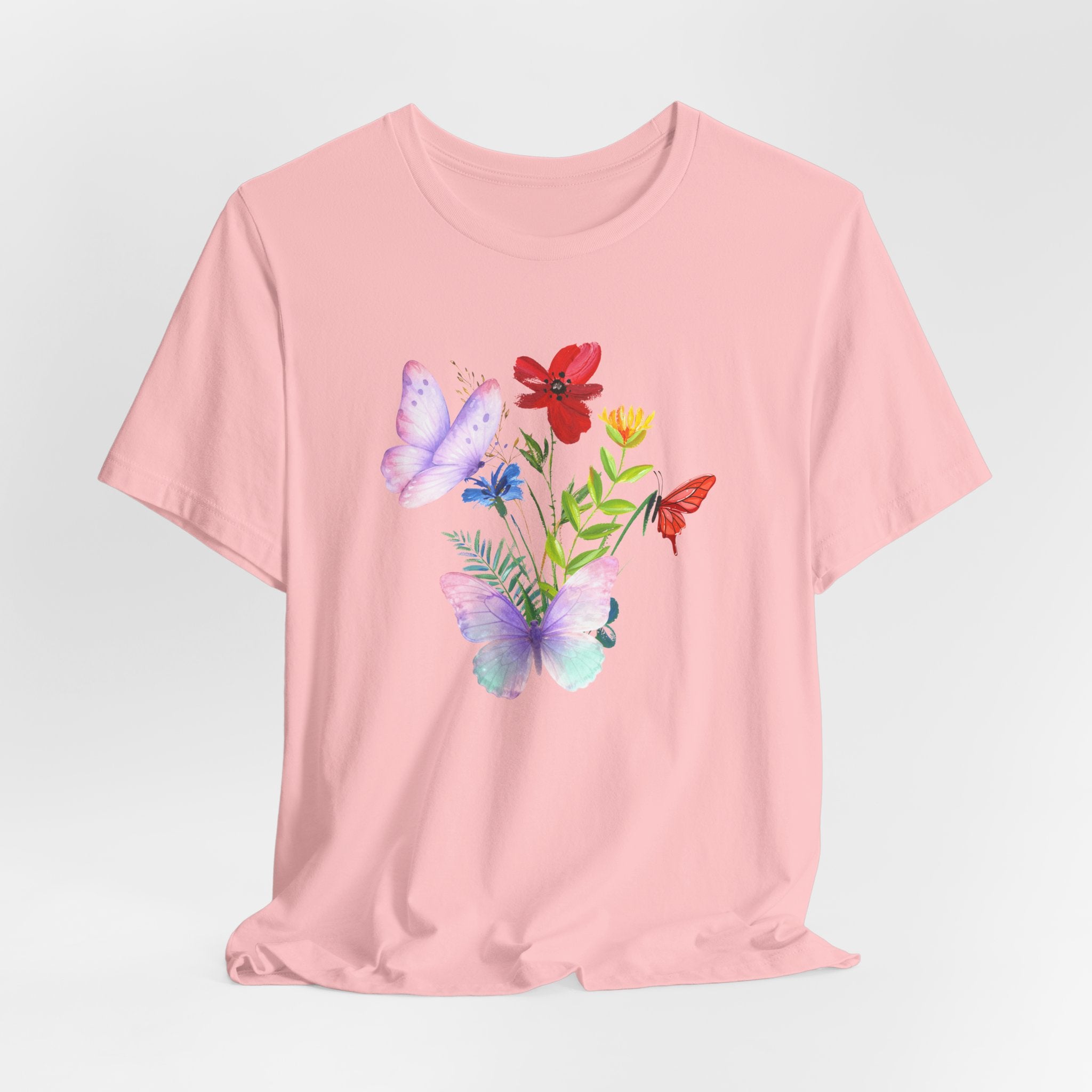 Pink t-shirt with floral and butterfly design on a light gray background
